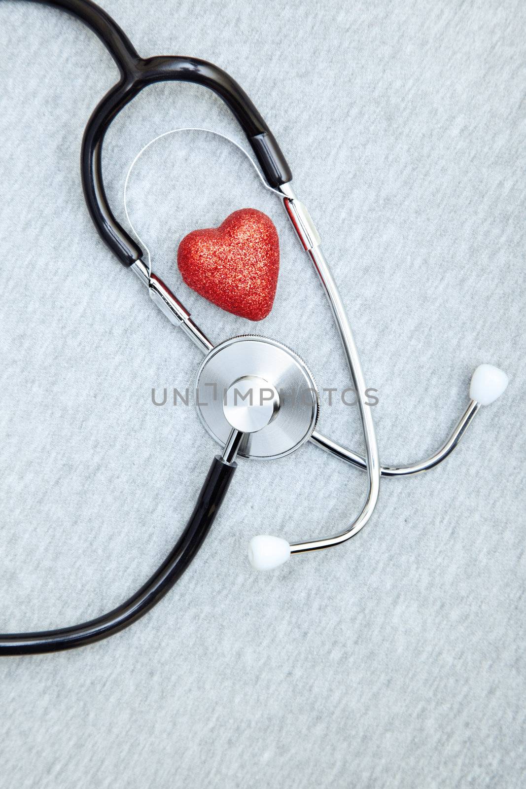 Medical stethoscope and heart on a textured background