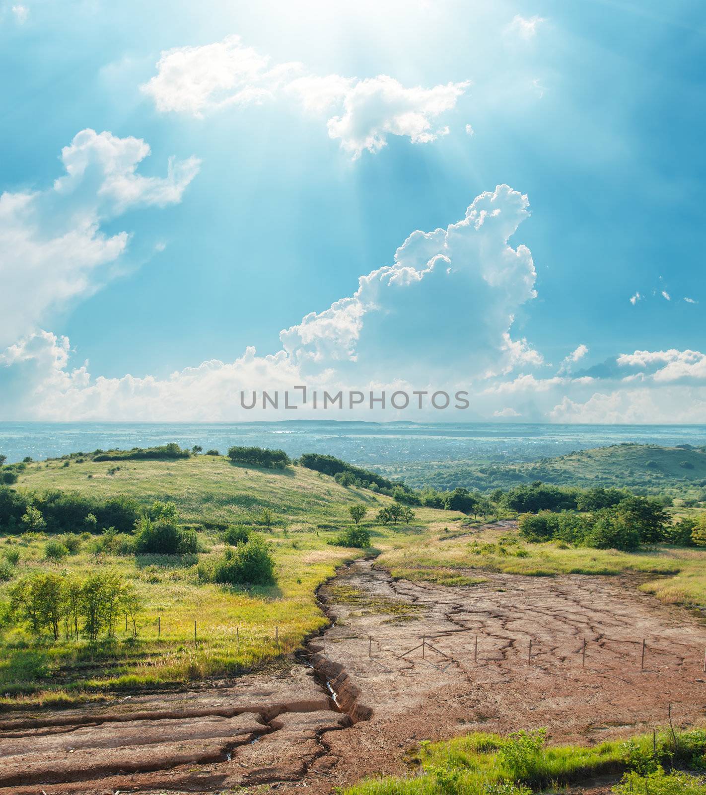 blue sky with clouds and sun over drought earth in mountains by mycola