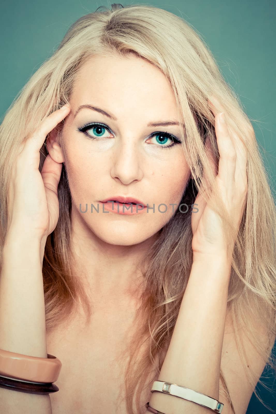 Close-up of a models face with a turquoise background