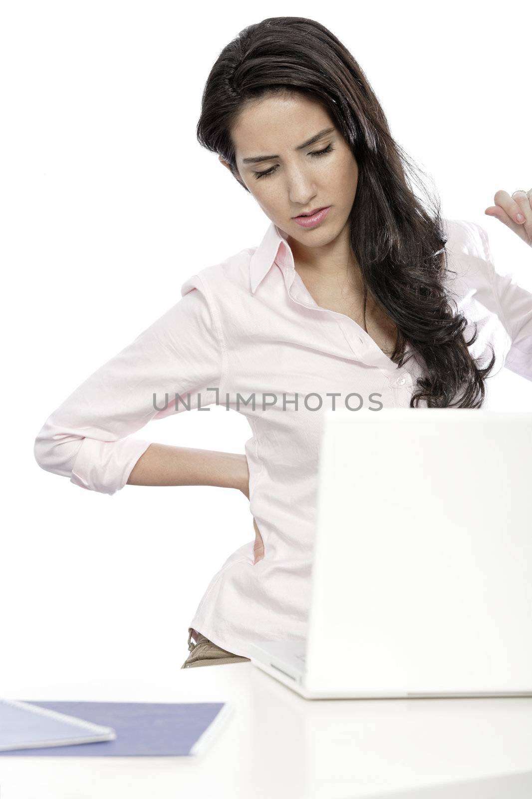 Beautiful young woman with back pain at her office desk