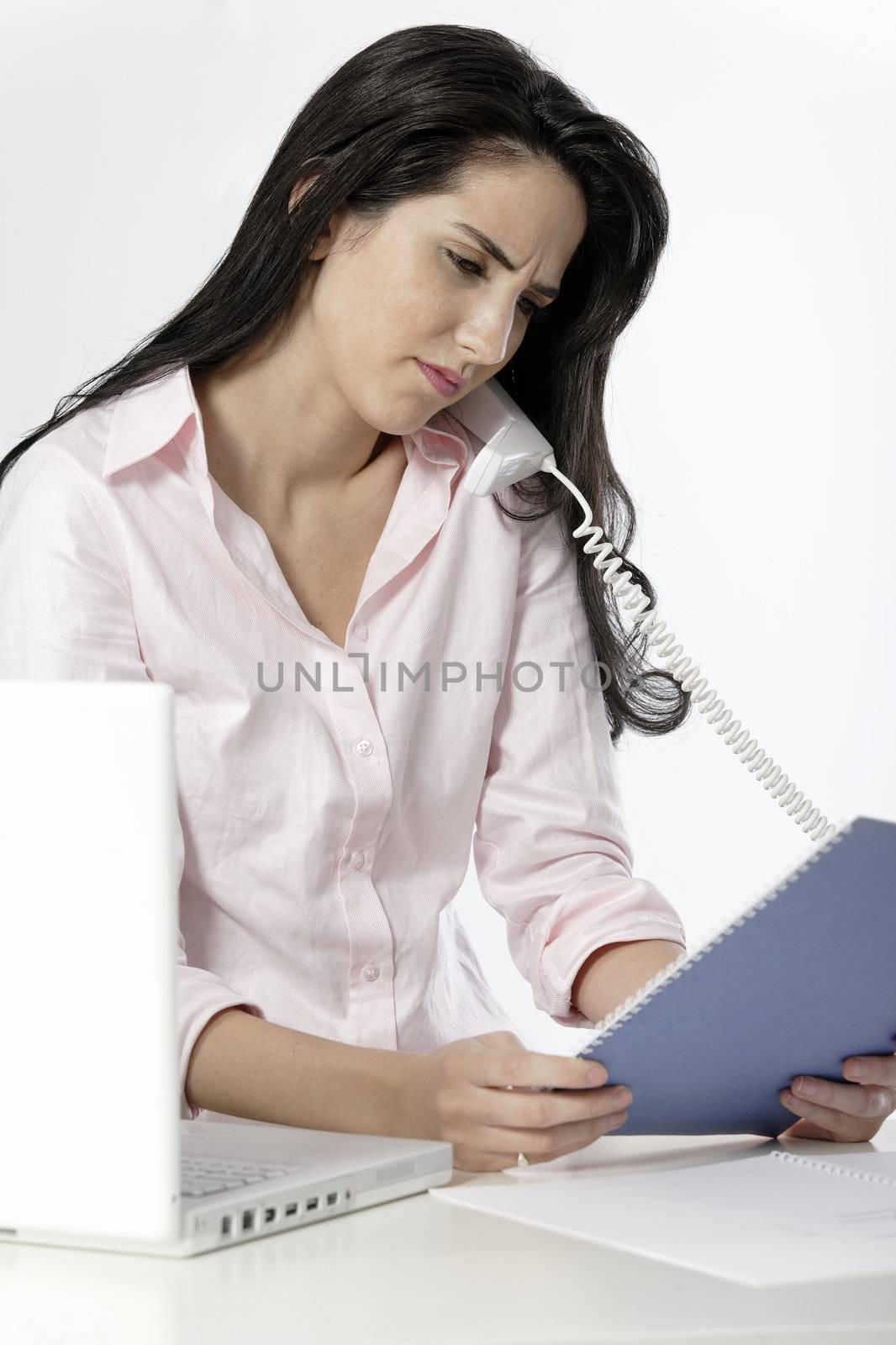 Beautiful young woman under stress at work at her office desk