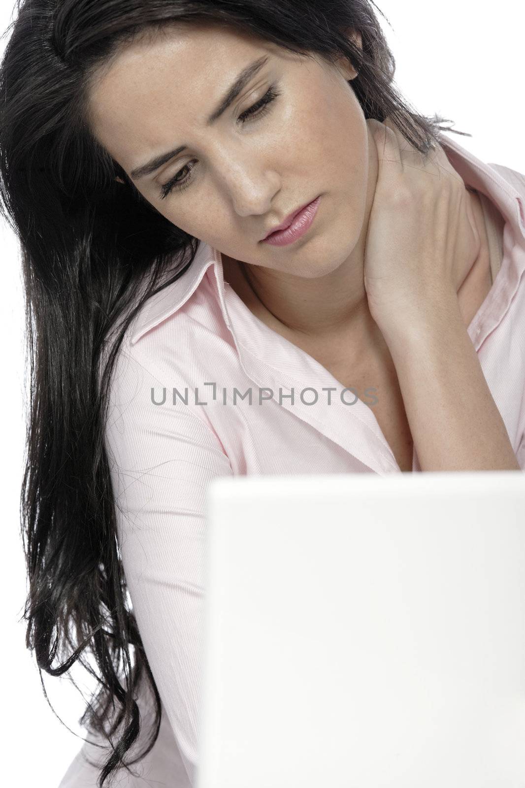 Beautiful young woman with neck pain at her office desk