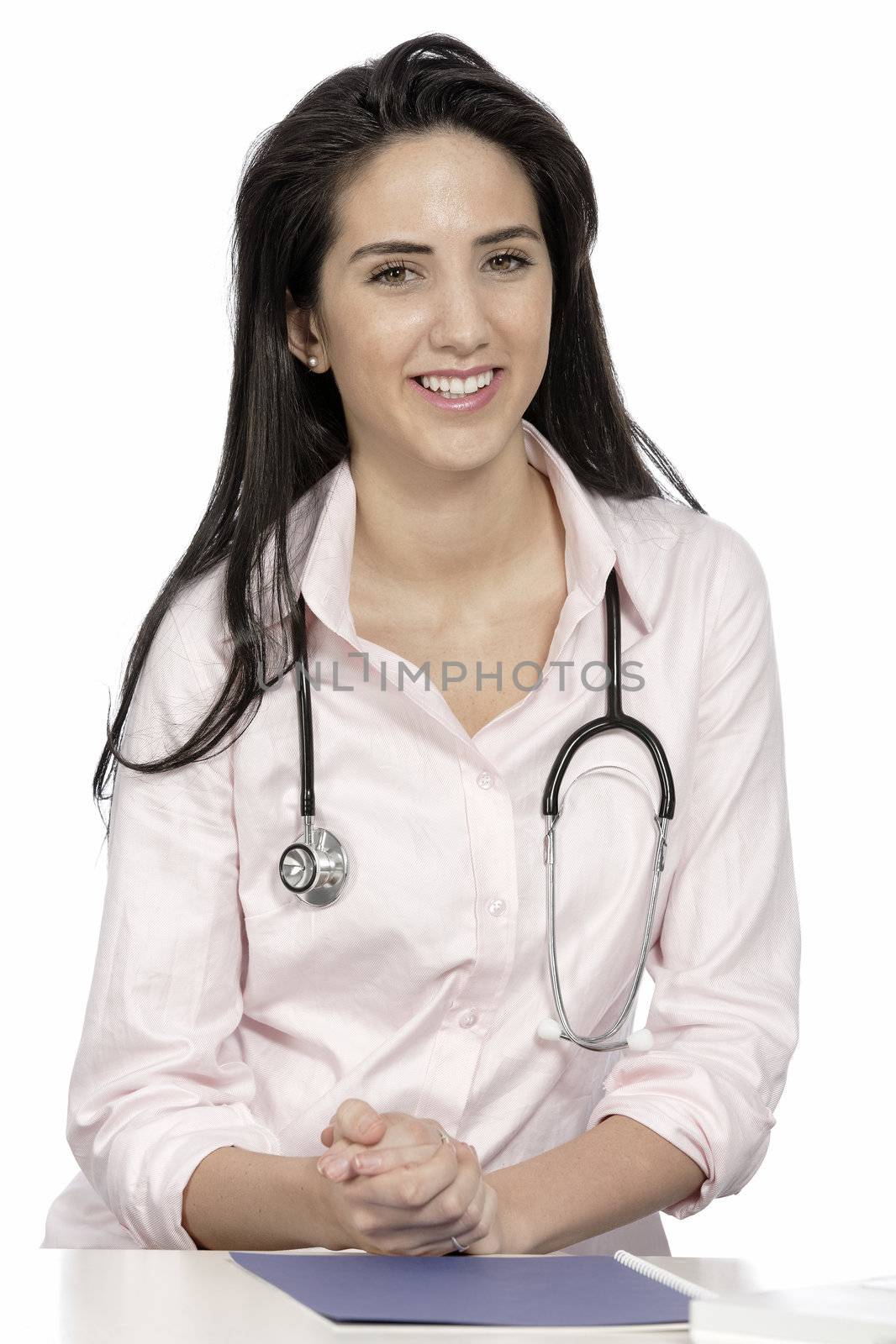 Beautiful young doctor sat smiling at her work desk