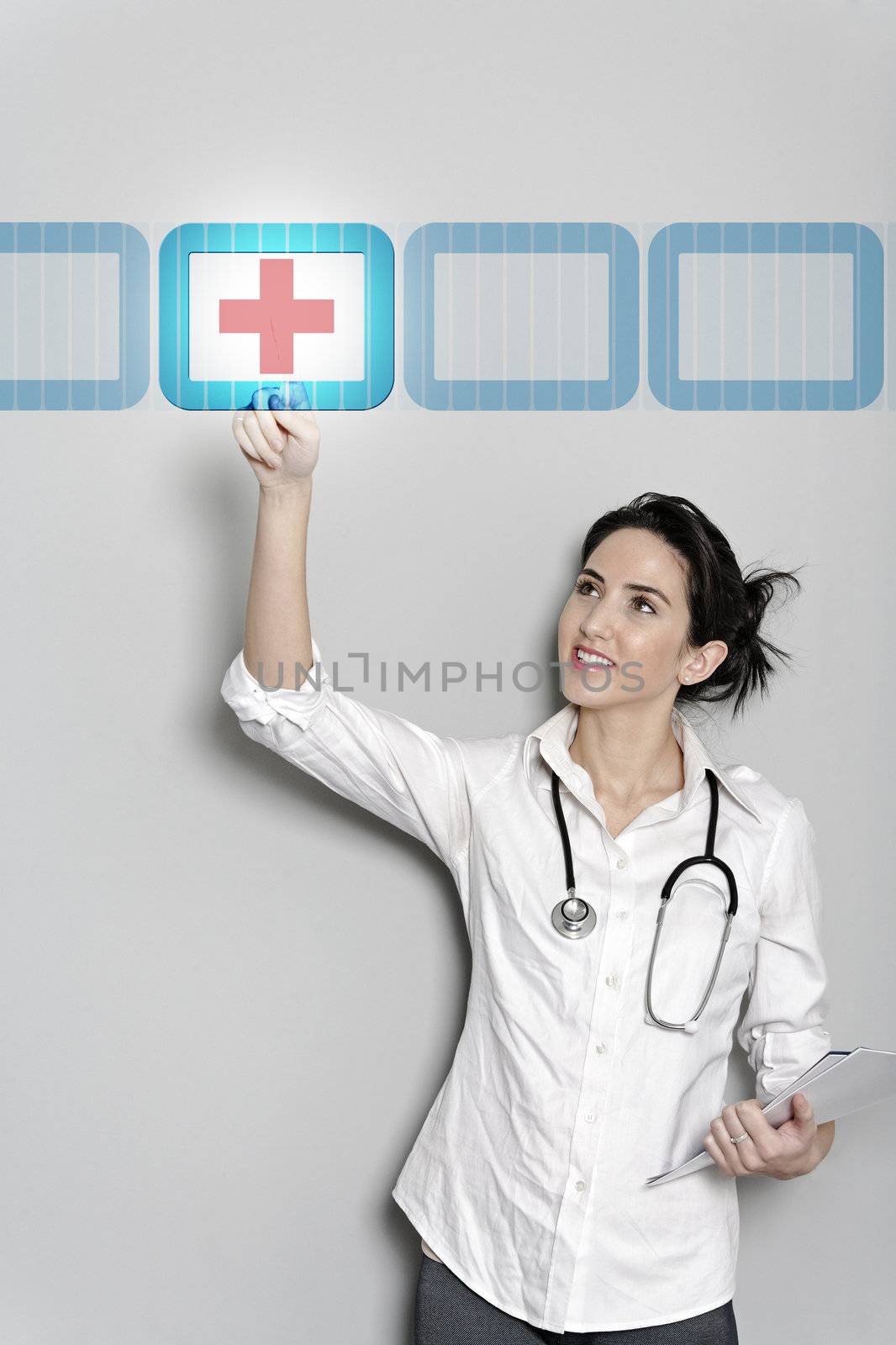 Beautiful female doctor pressing a concept red cross button