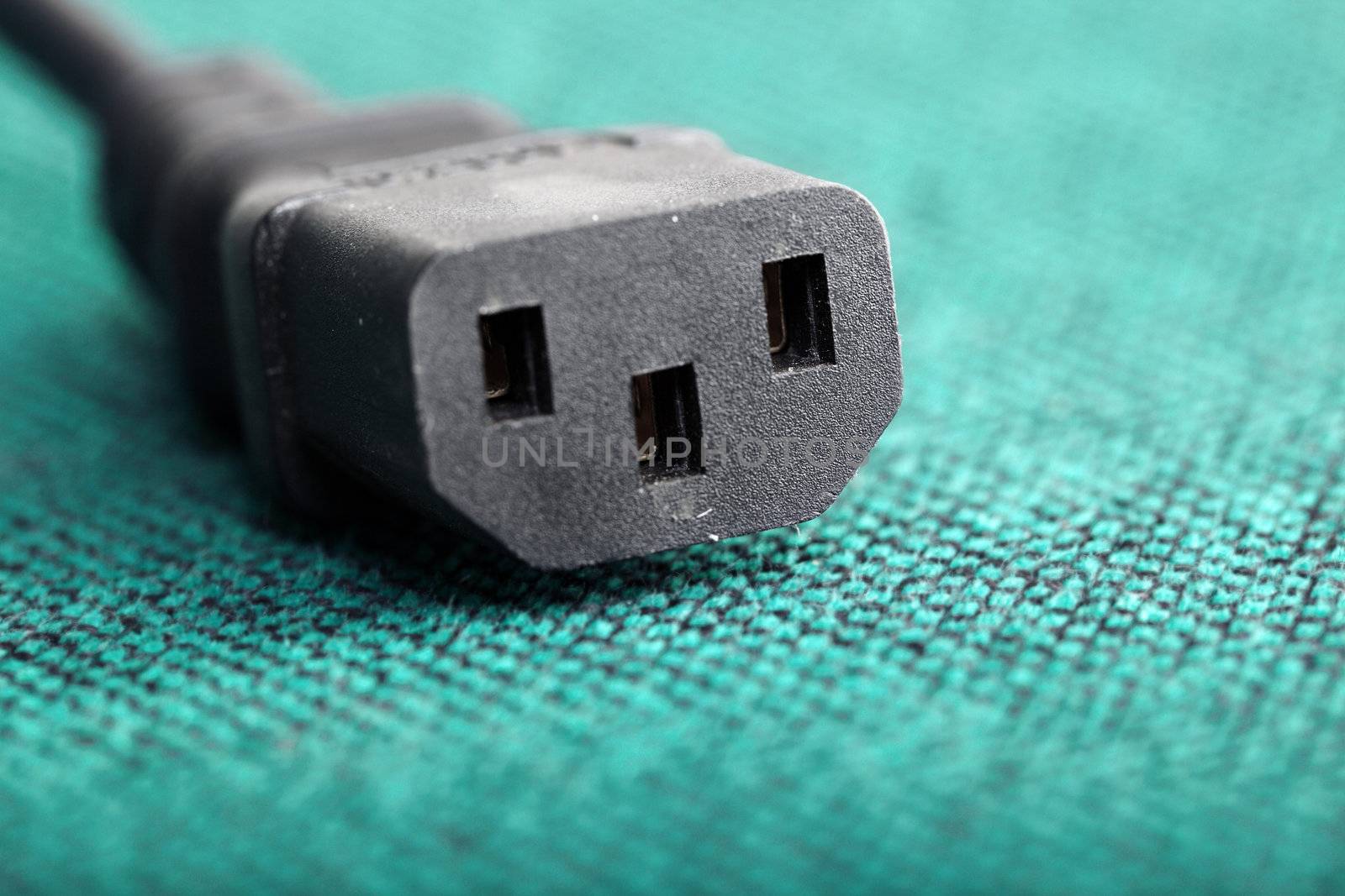 Macro photo of the black power connector on the green background