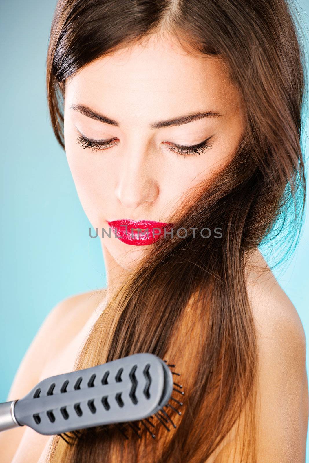 woman with long hair holding comb by imarin