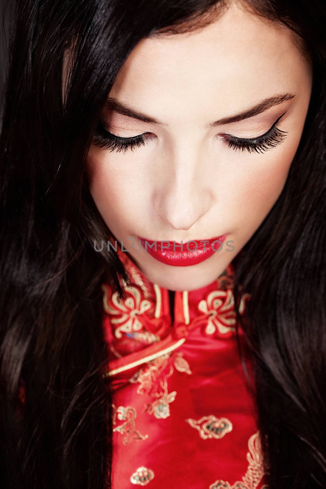 pretty woman in red Cheongsam on dark background