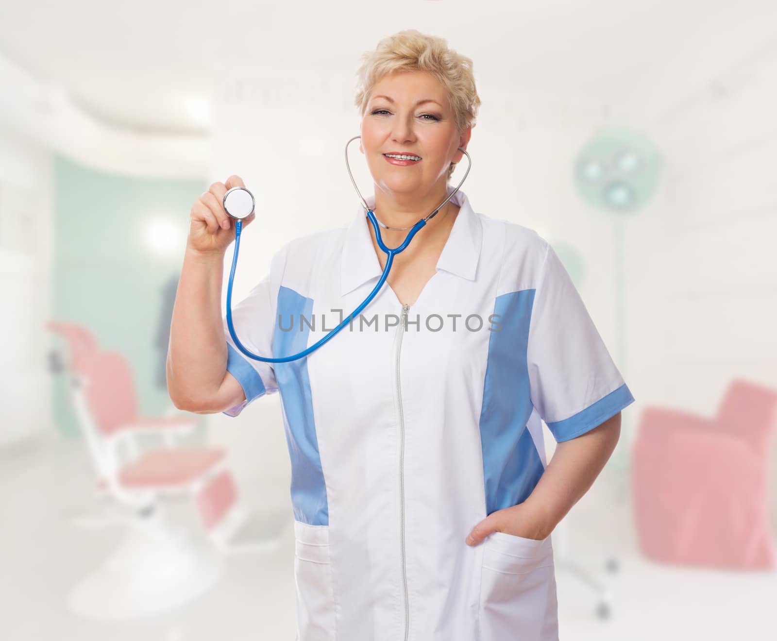 Mature doctor with stethoscope at medical office