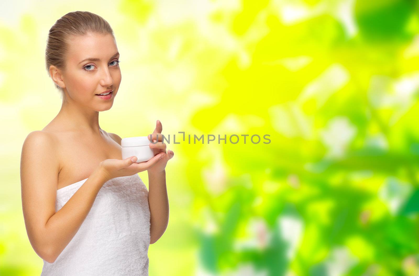 Young girl with body cream jar on floral spring background
