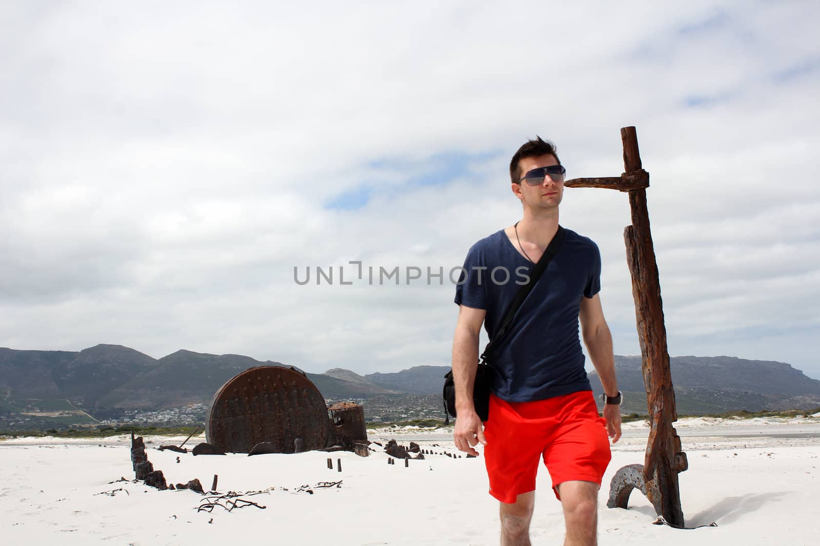 Man walking at Shipwreck Kakapo at the beach of kommetjie with upcoming storm in the background
