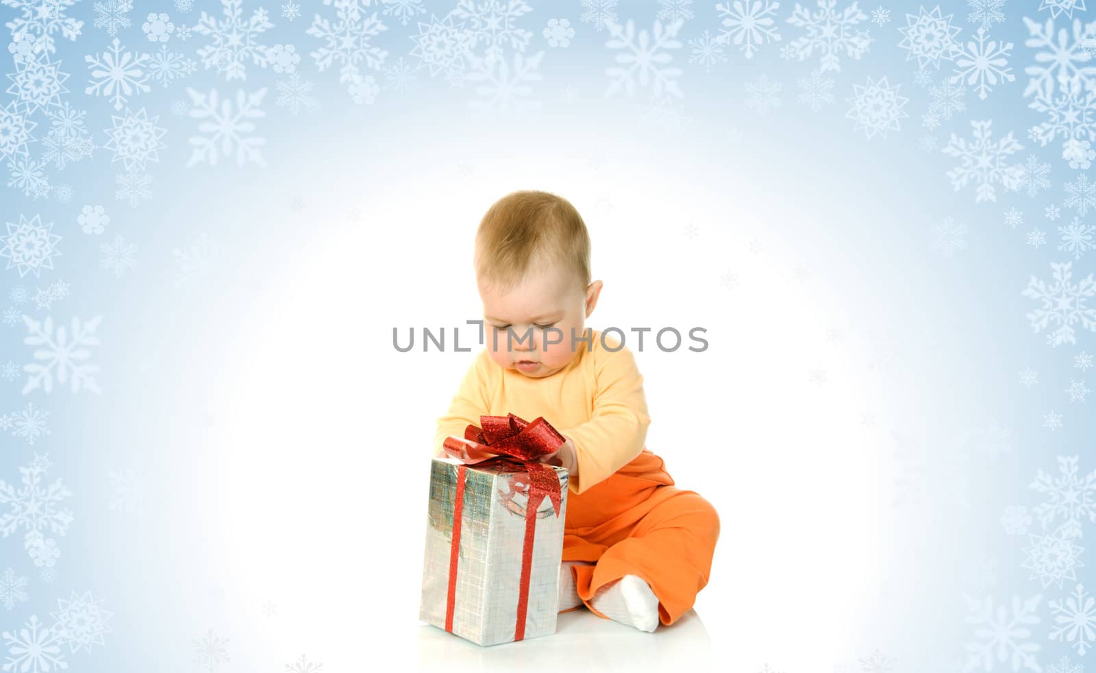 Sitting small baby on blue background with snowflakes