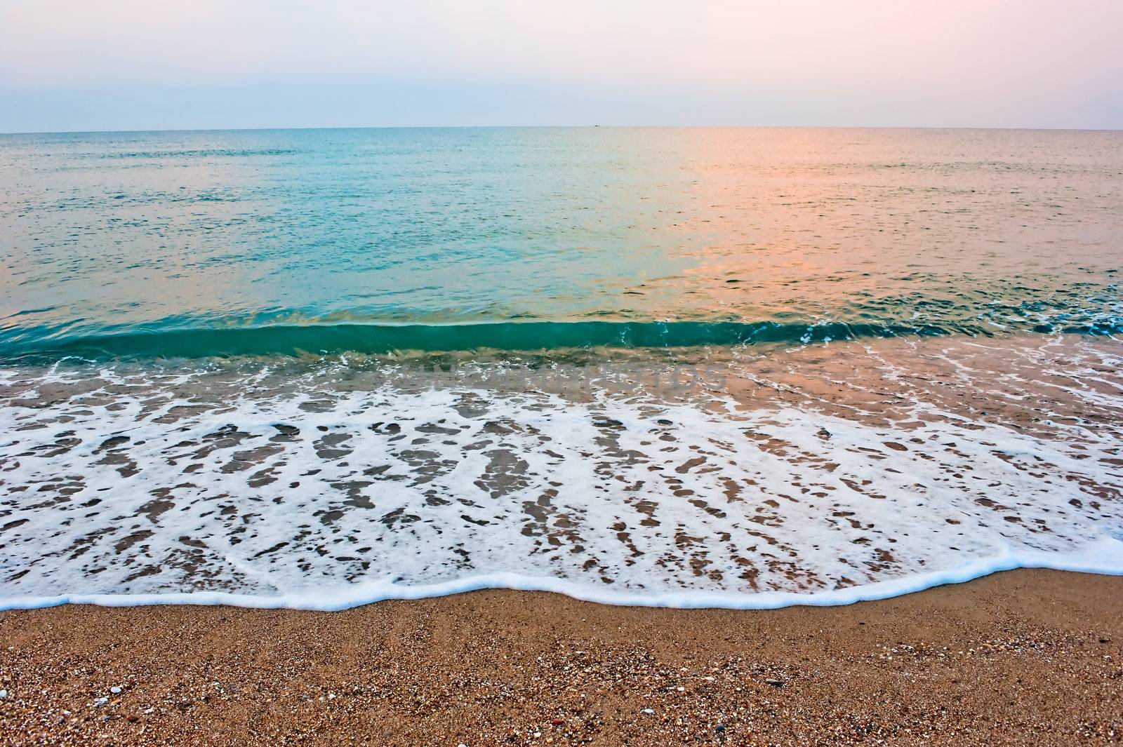 Splash of sea foam on a sandy beach