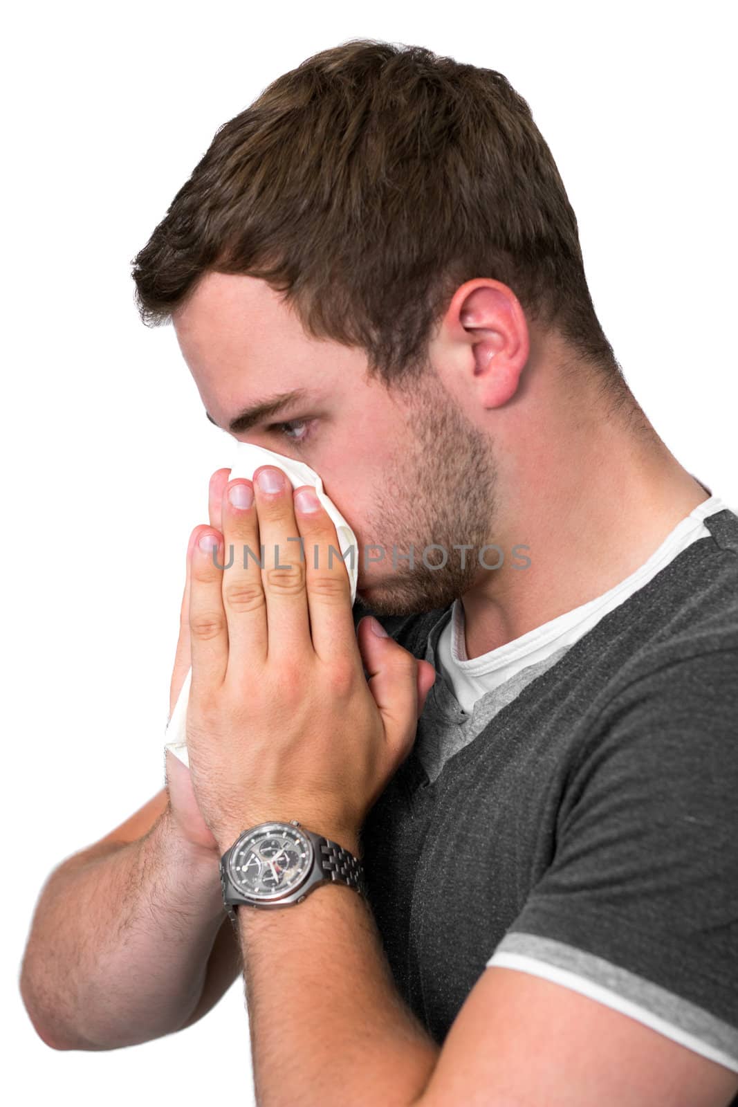 Young Man Blowing Nose into a tissue