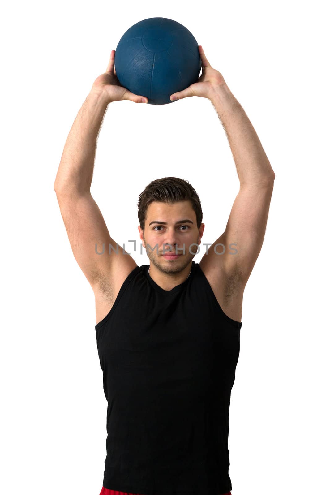 Attractive brunette man in a black tank top and red pants working out with a medicine ball