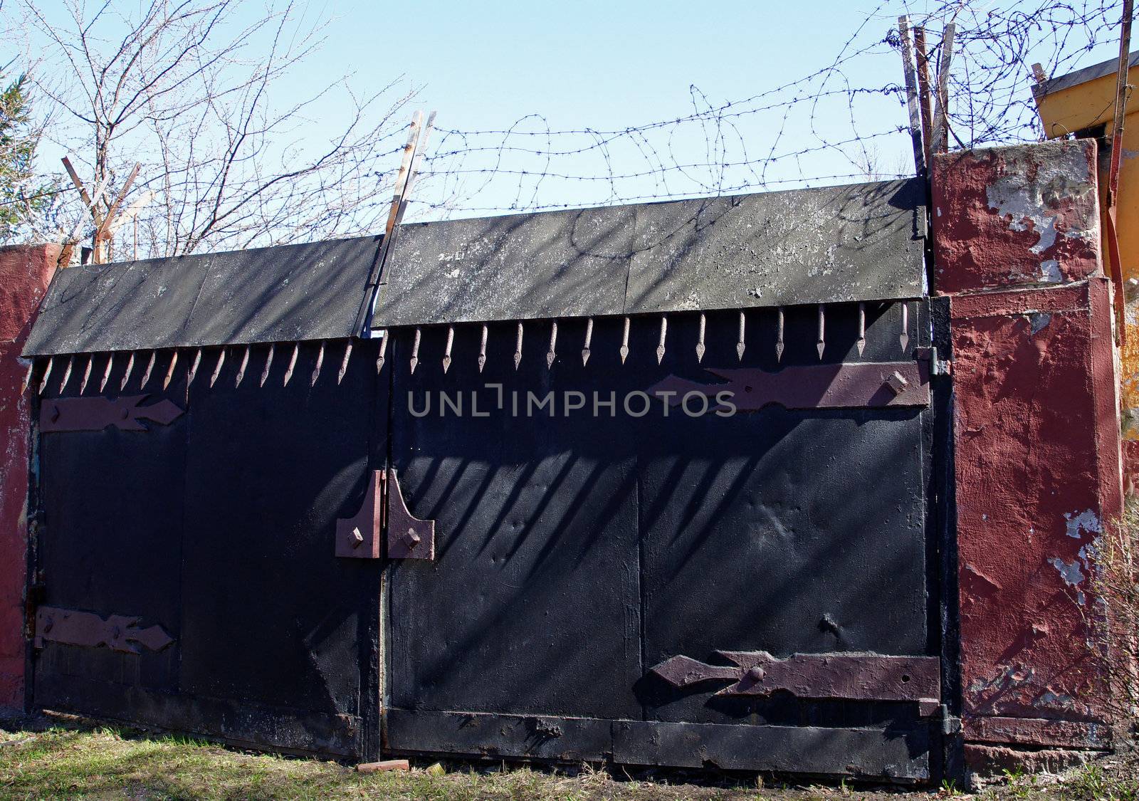 Old metal gate with a barbed wire