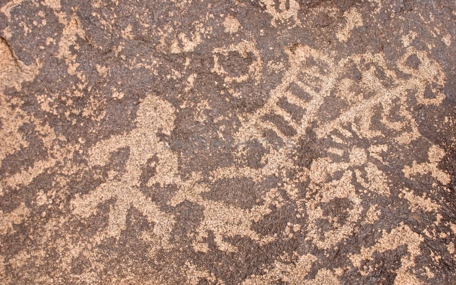 Ancient symbols carved into rocks in the Arizona desert showing a man, ladder and the sun