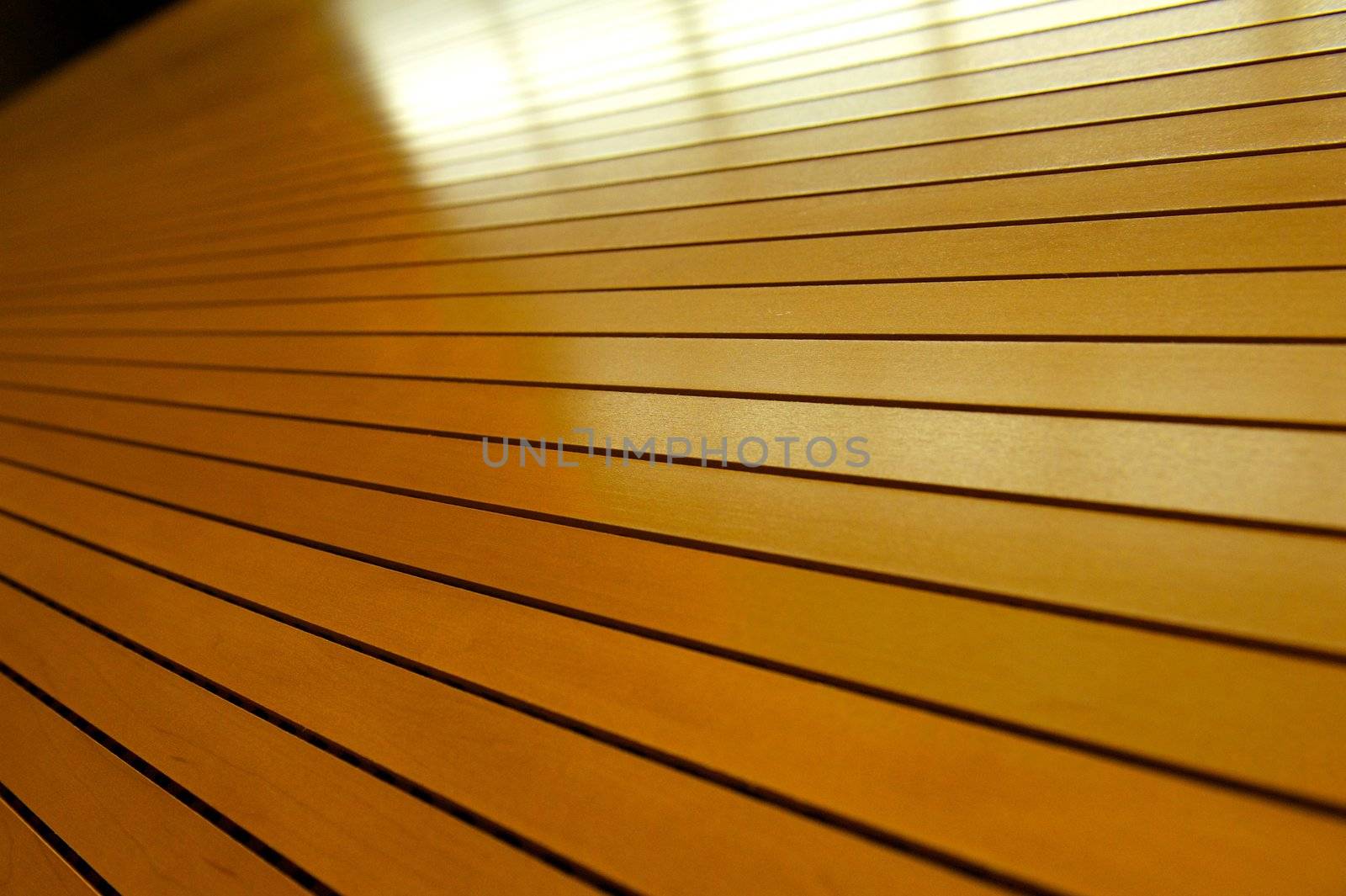 Rows of tightly fitted wooden slats form disappear into infinity with reflections of light