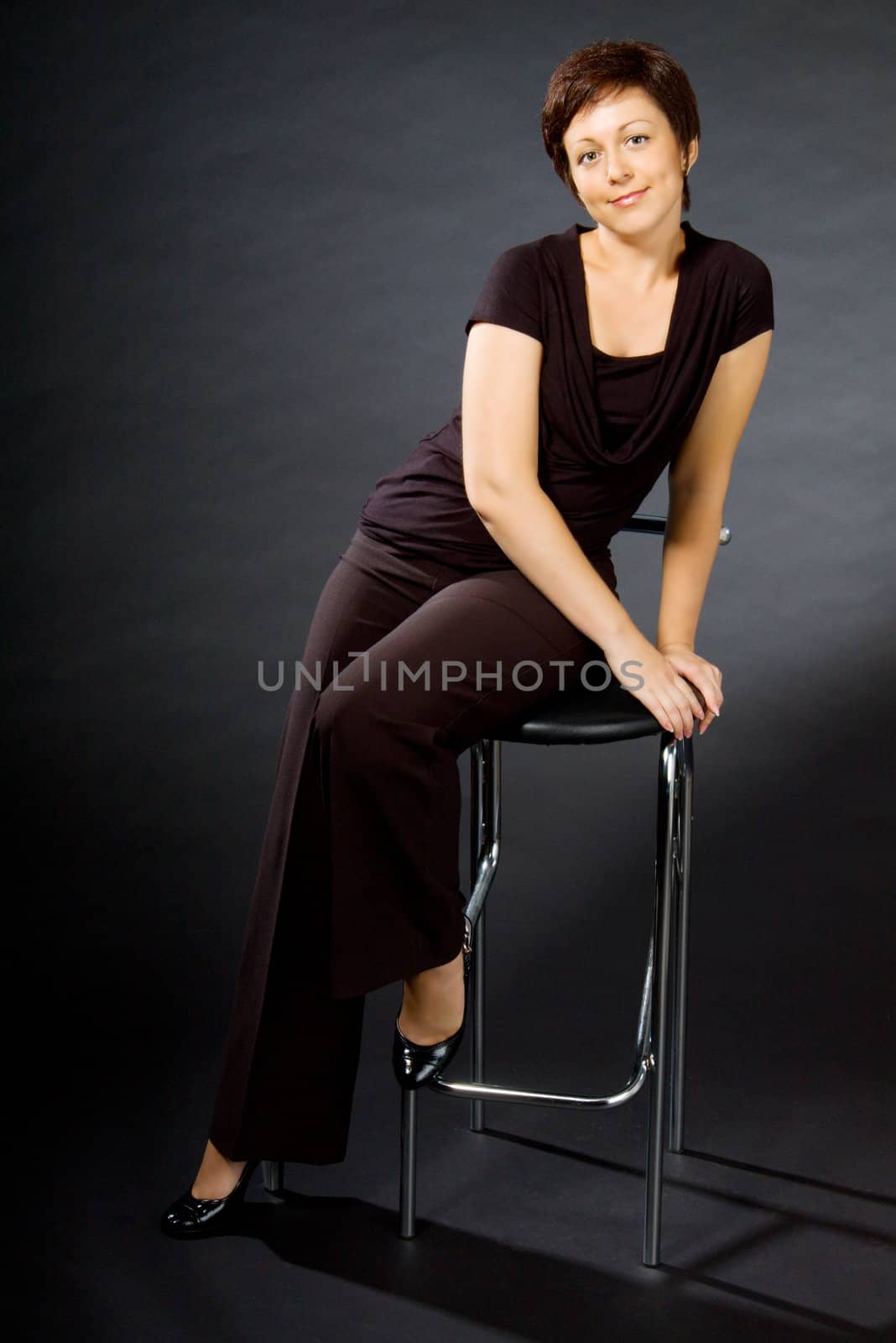 Studio portrait of young woman sitting on chair