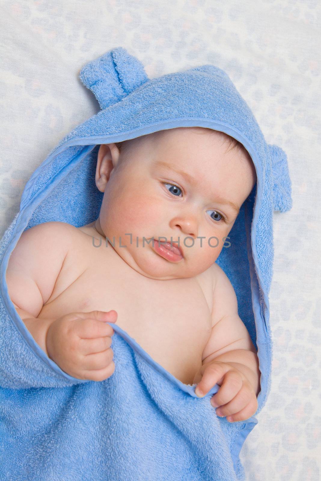 Small smiling baby in blue towel