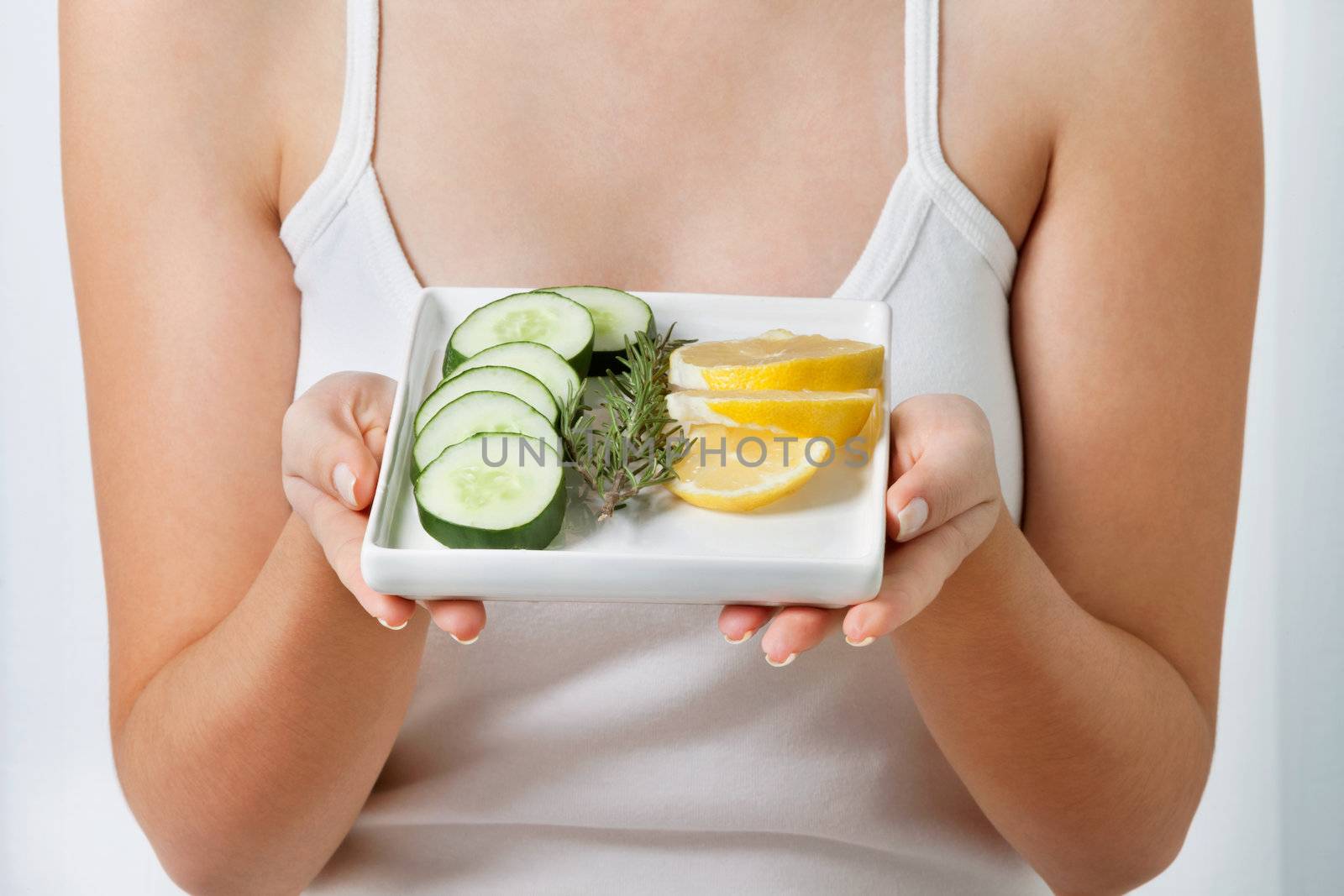 Woman With Plate Of Sliced Cucumber And Lime by leaf