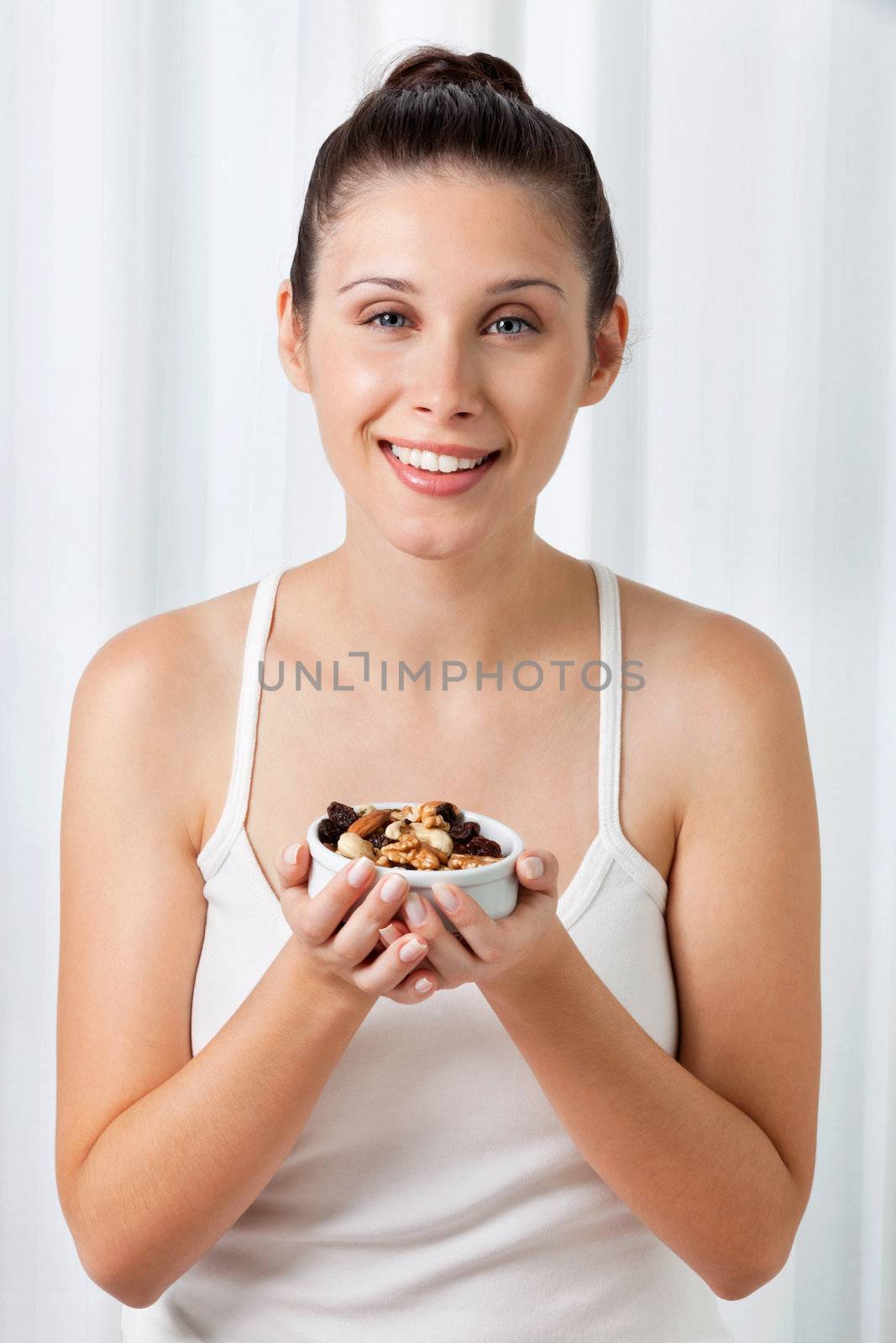 Woman Holding Bowl Of Dry Fruits by leaf