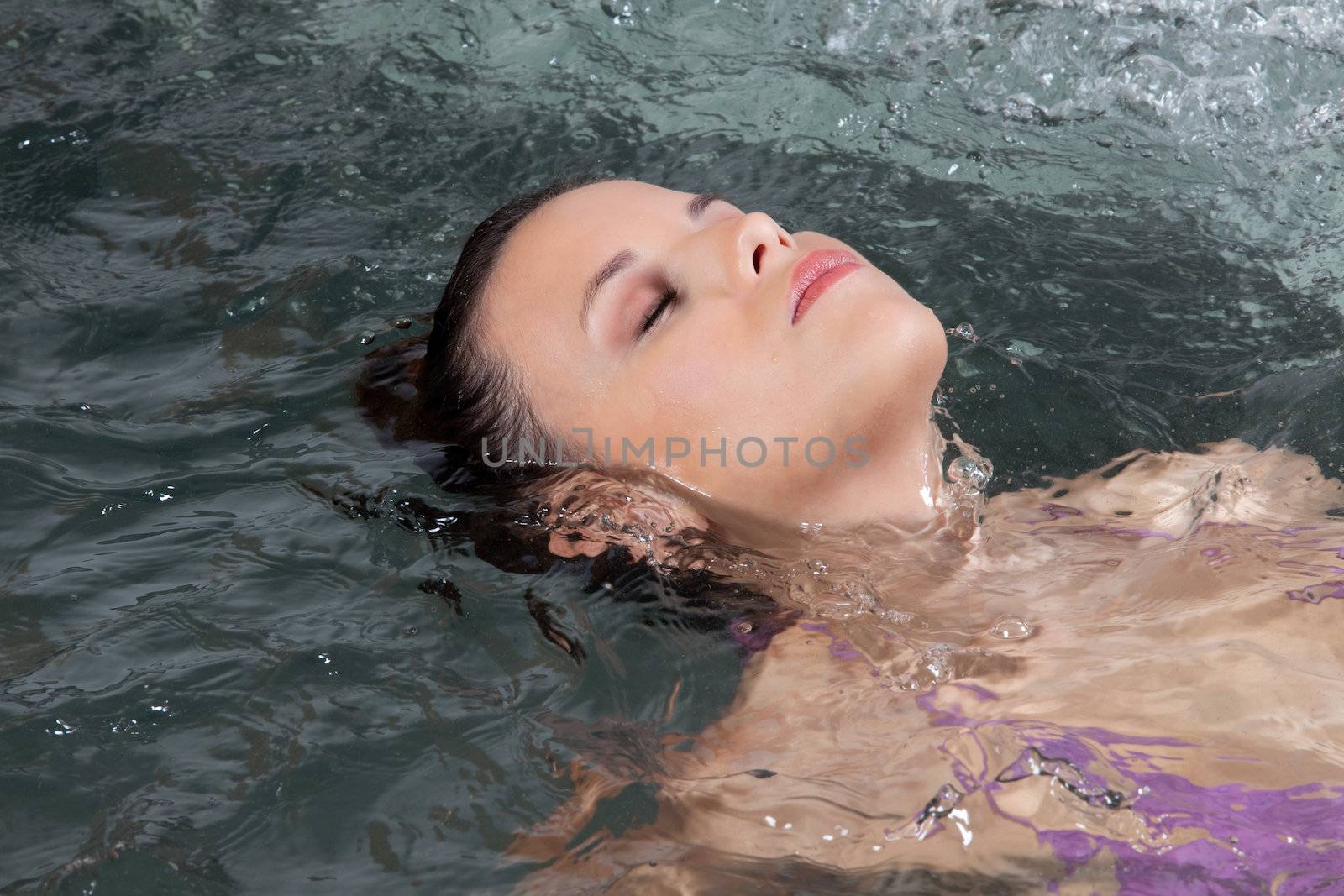 Woman lying in bath by leaf