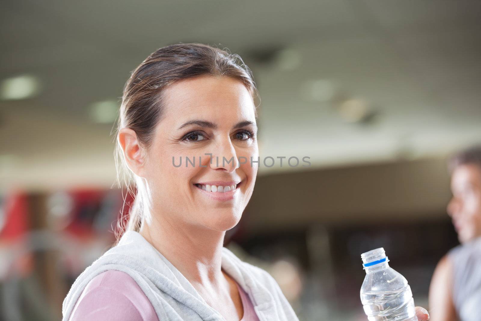 Woman Holding Bottle Of Water At Health Club by leaf
