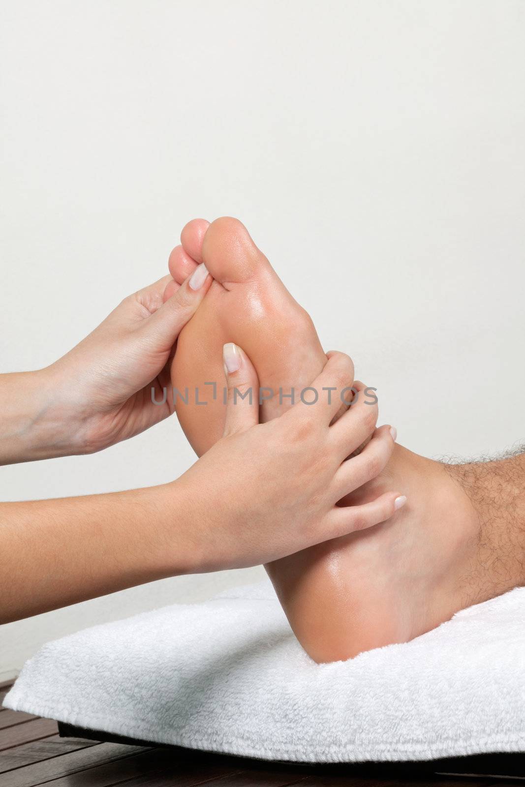 Close up of female masseuse massaging man's foot