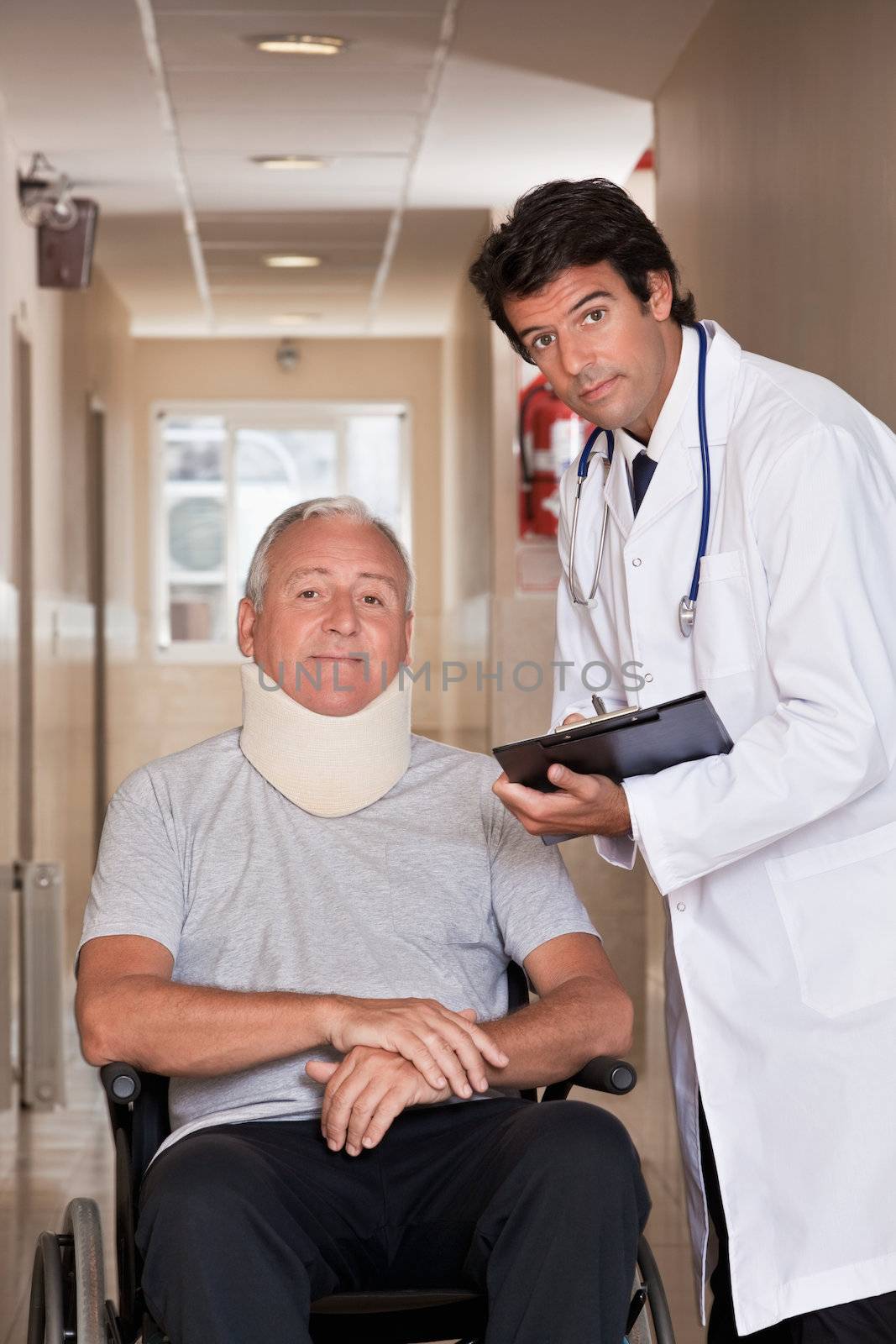 Doctor with patient wearing neck brace in wheelchair.
