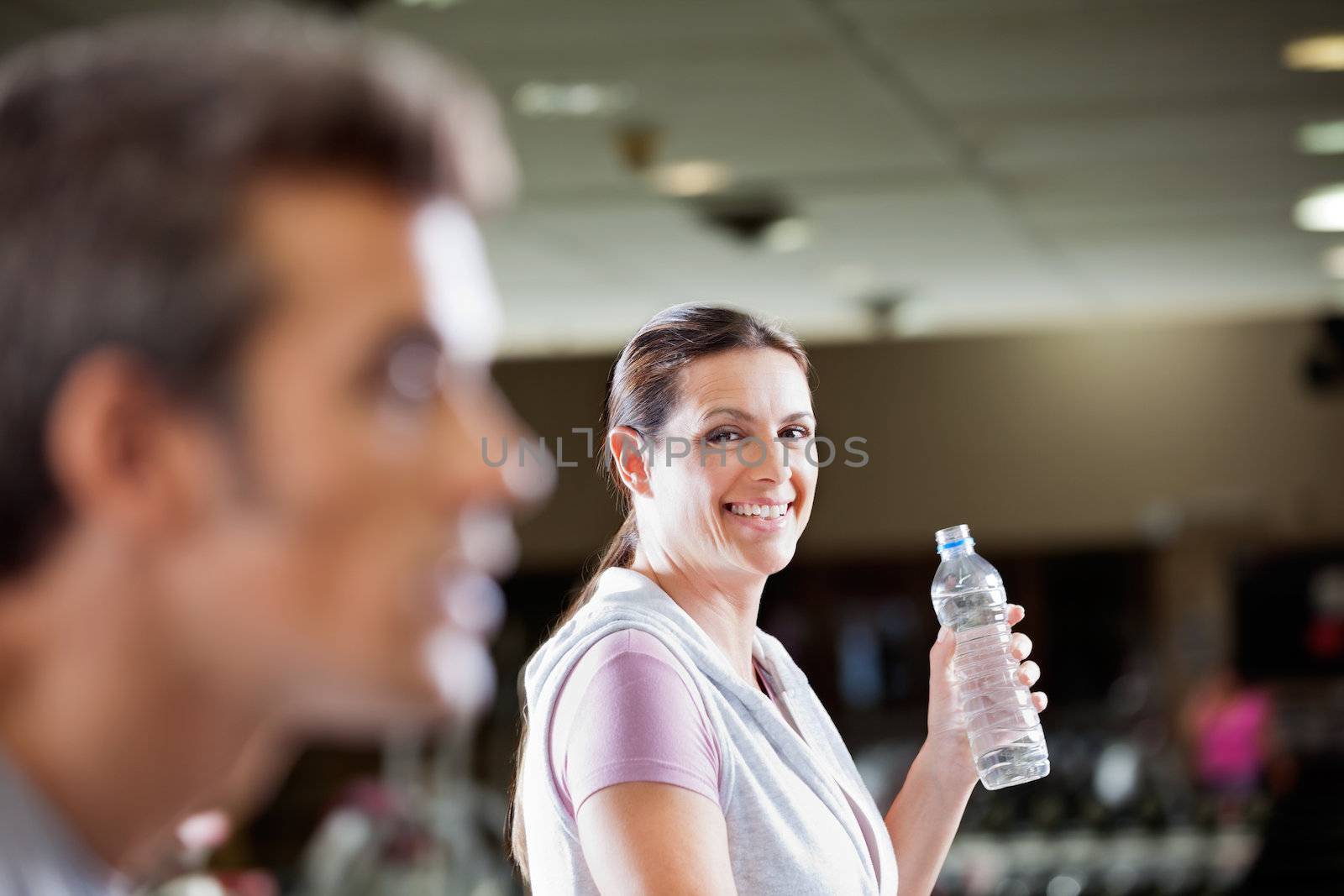 Woman Holding Bottle Of Water At Health Club by leaf