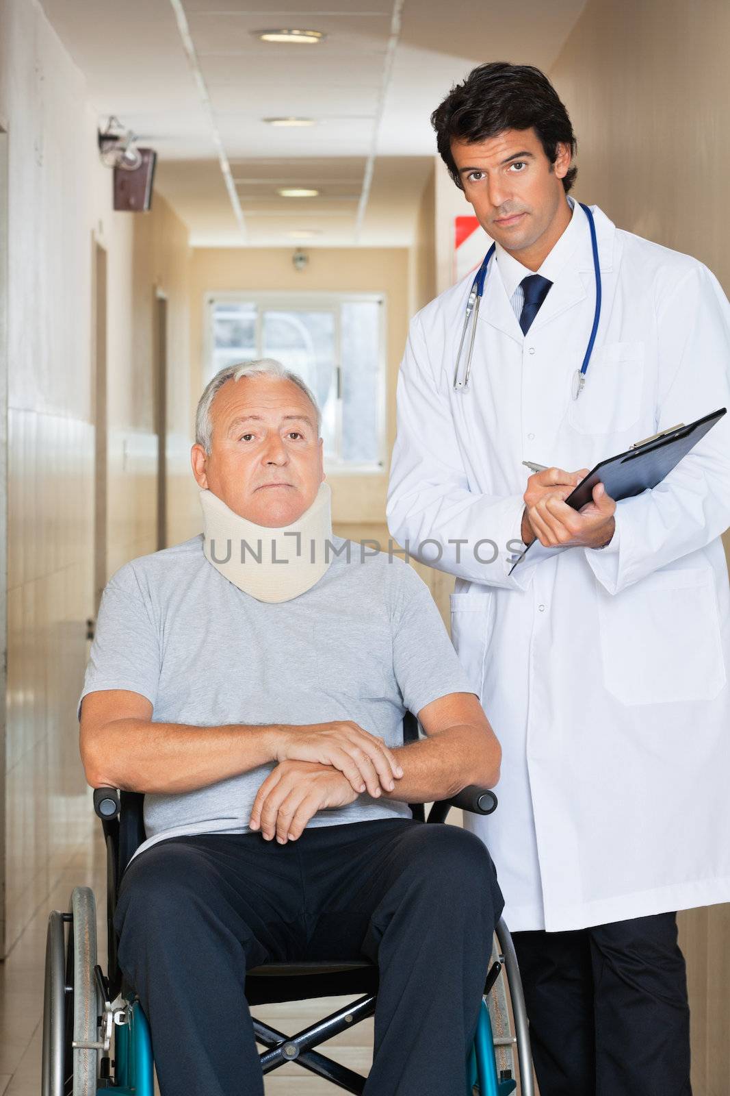 Young doctor writing on clipboard by senior man sitting on wheel chair with neck brace