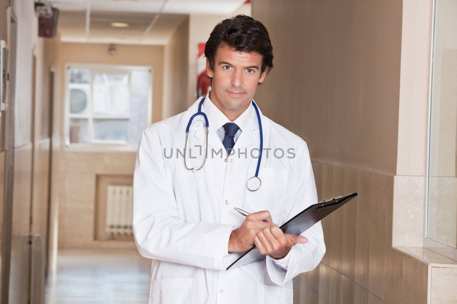 Male Doctor standing with folder at hospital.