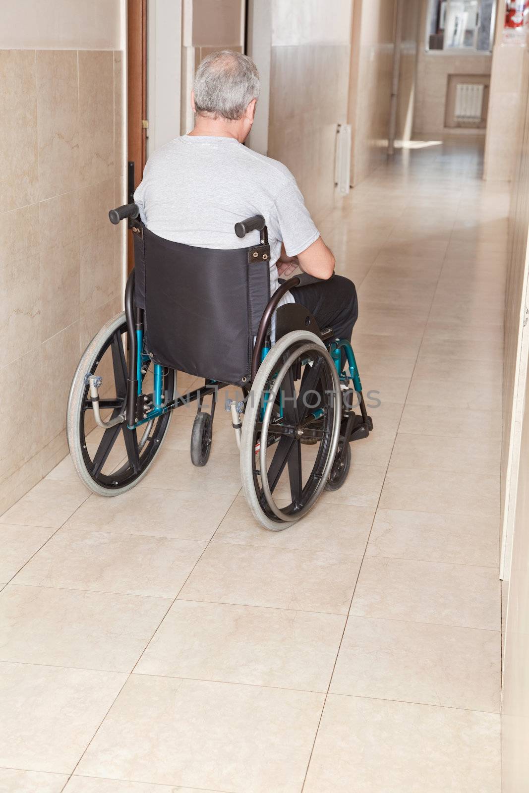 Retired man on wheelchair at hospital.