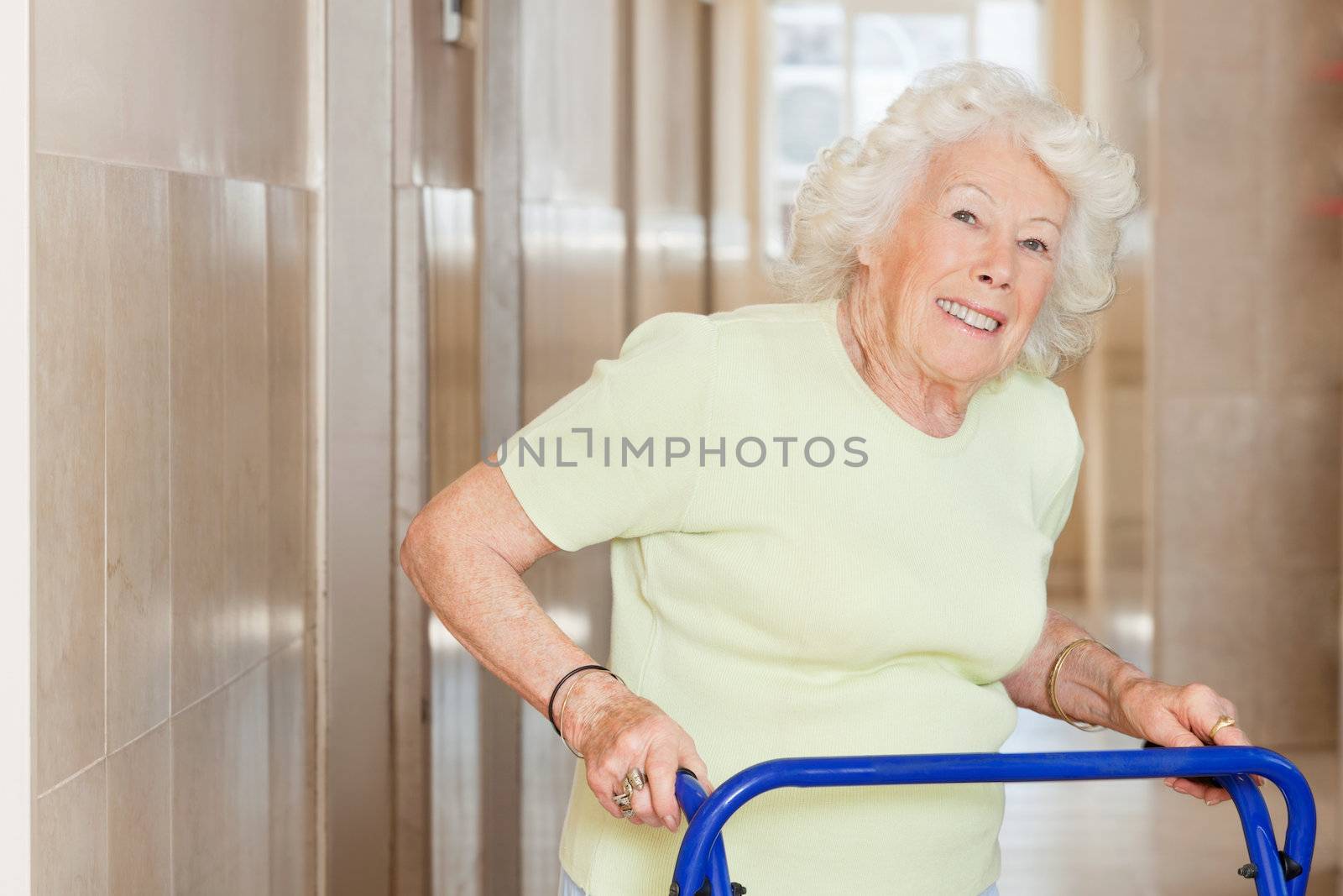 Happy Senior Woman Using Zimmer Frame by leaf