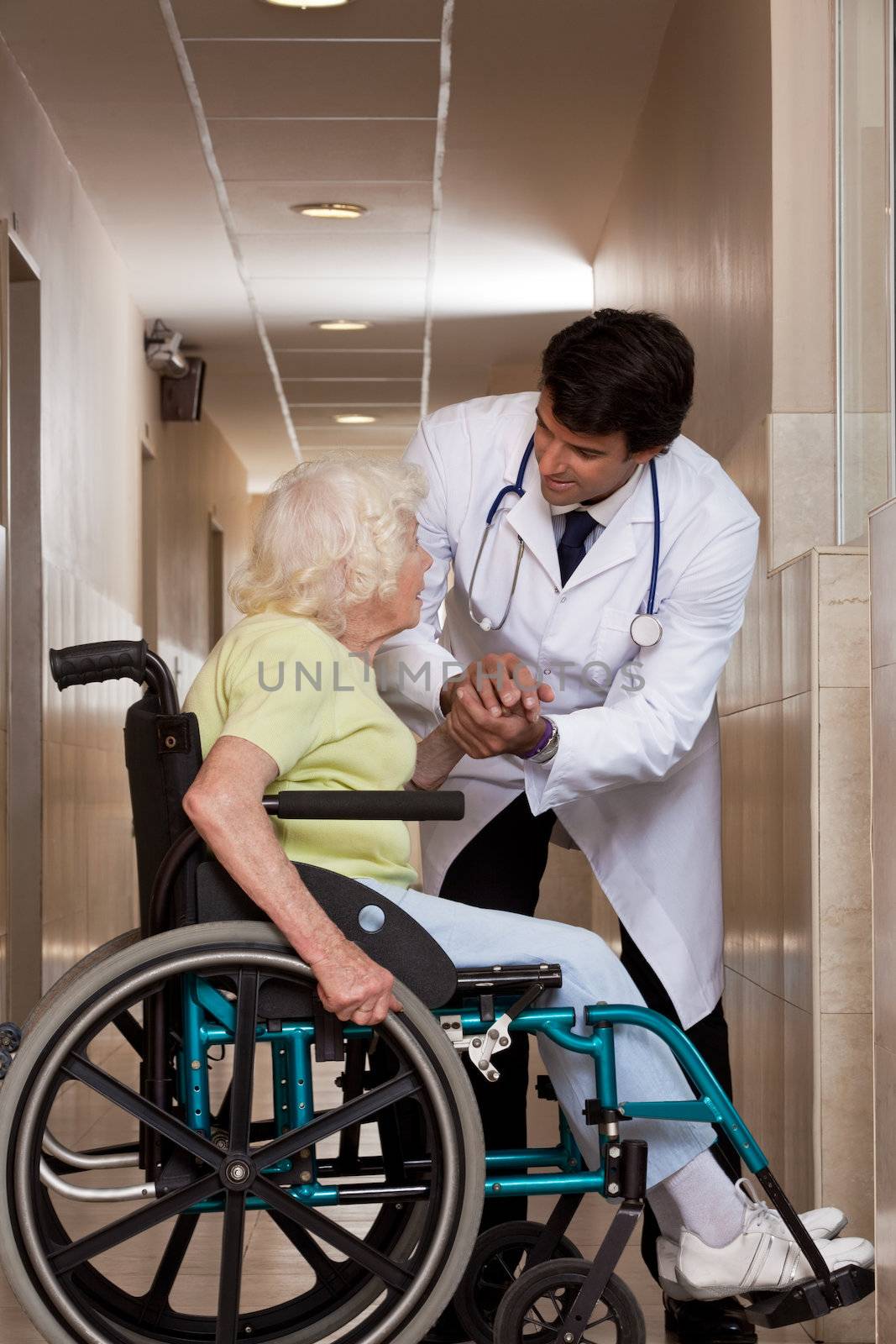 Doctor with patient on wheel chair at hospital.