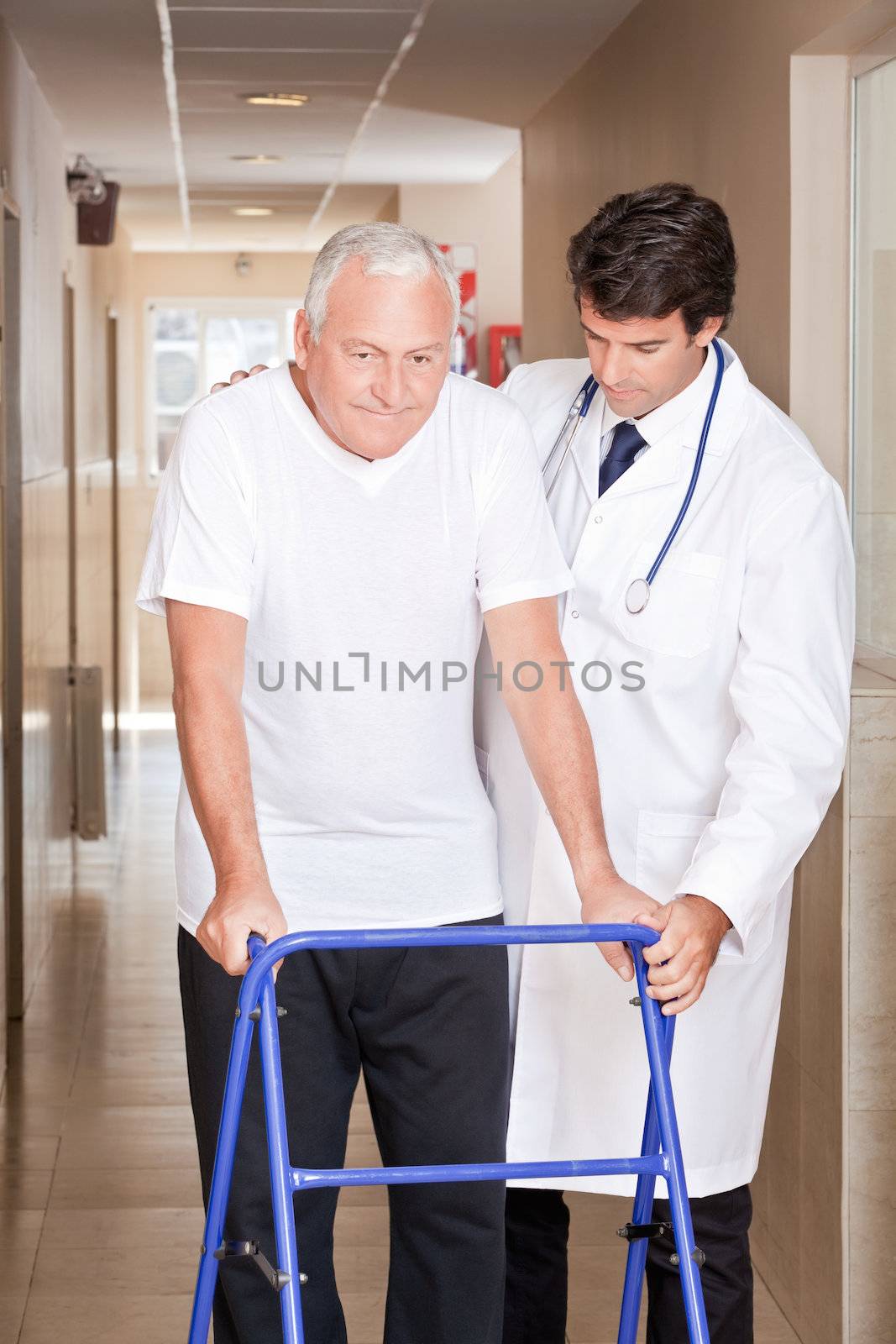 A doctor assisting a senior citizen onto his walker.