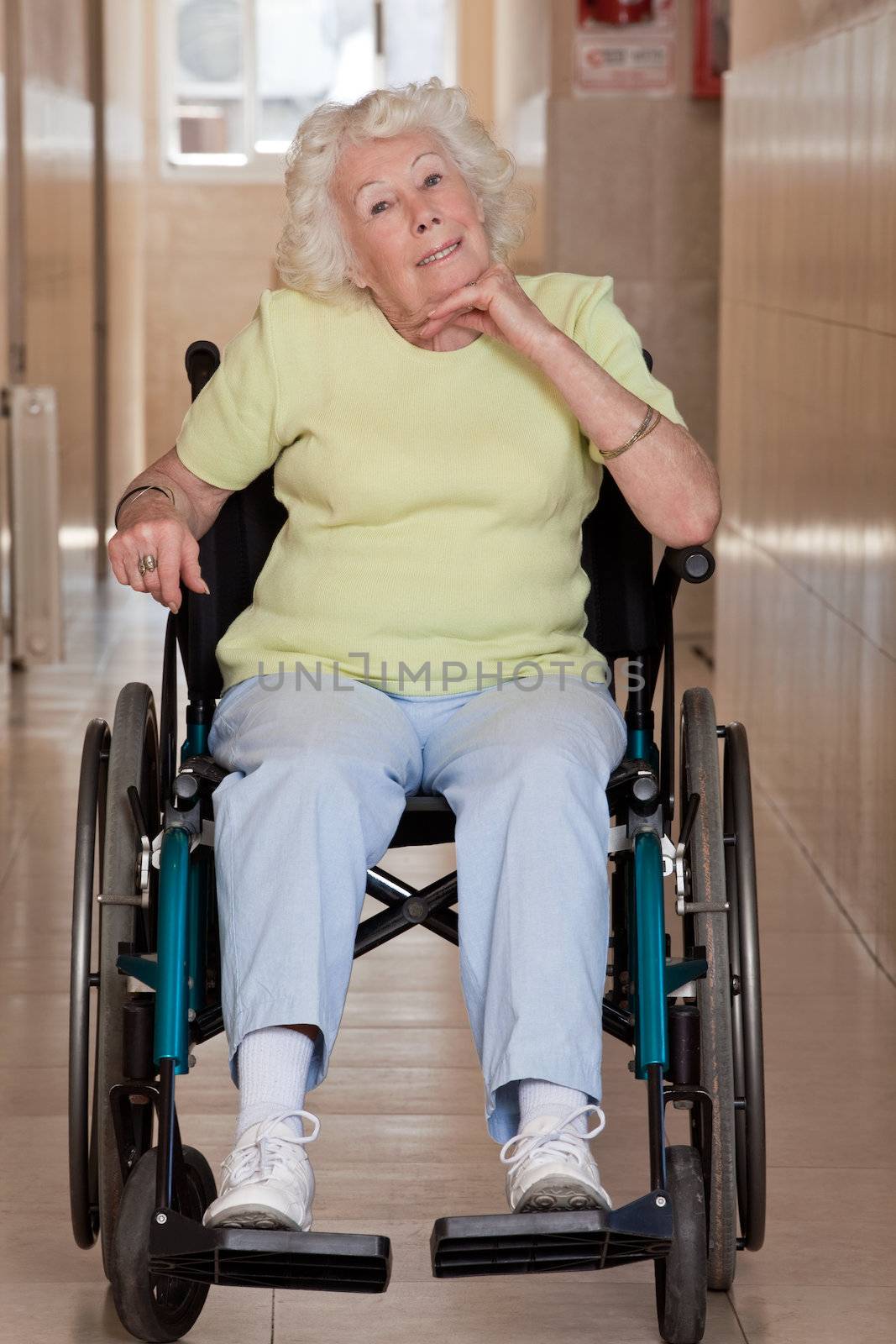 Retired woman on wheelchair at hospital.