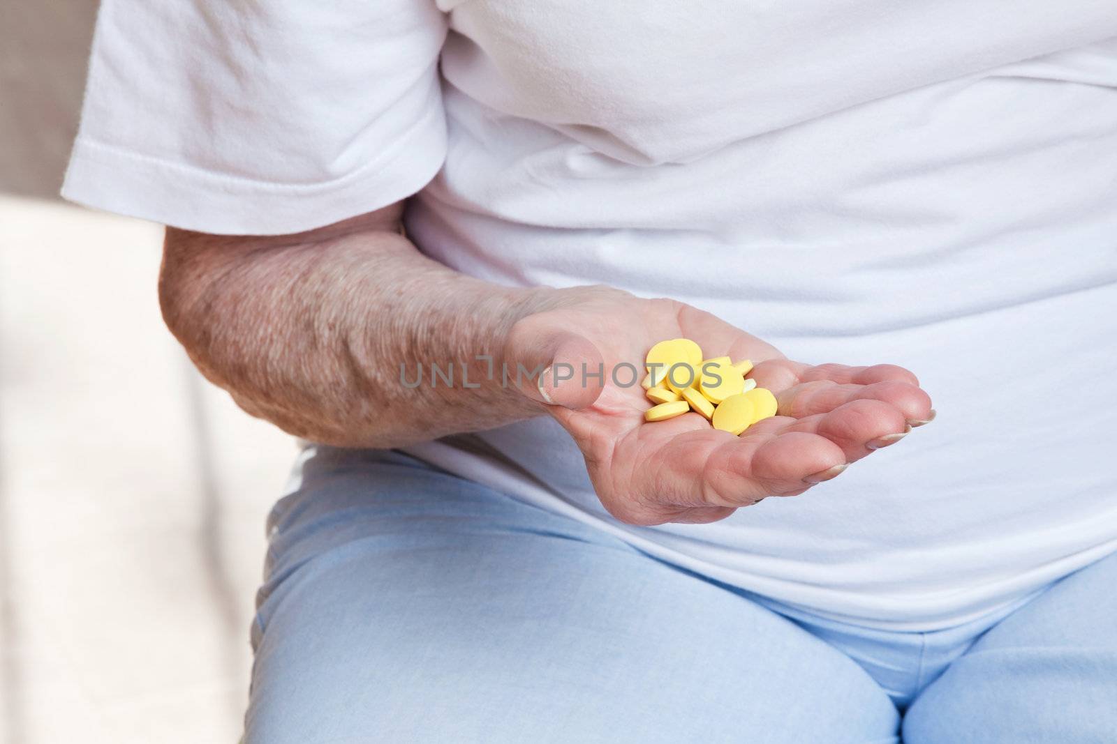 Sick senior woman holding her pills.