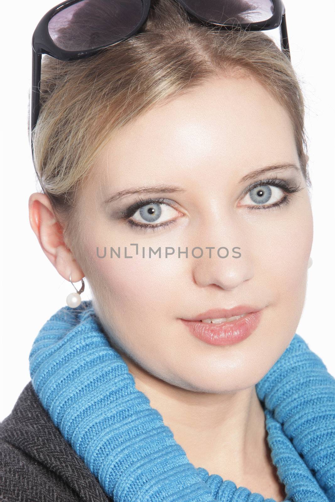 Closeup headshot portrait of a beautiful green eyed woman with her blonde hair tied up neatly looking into the camera isolated on white