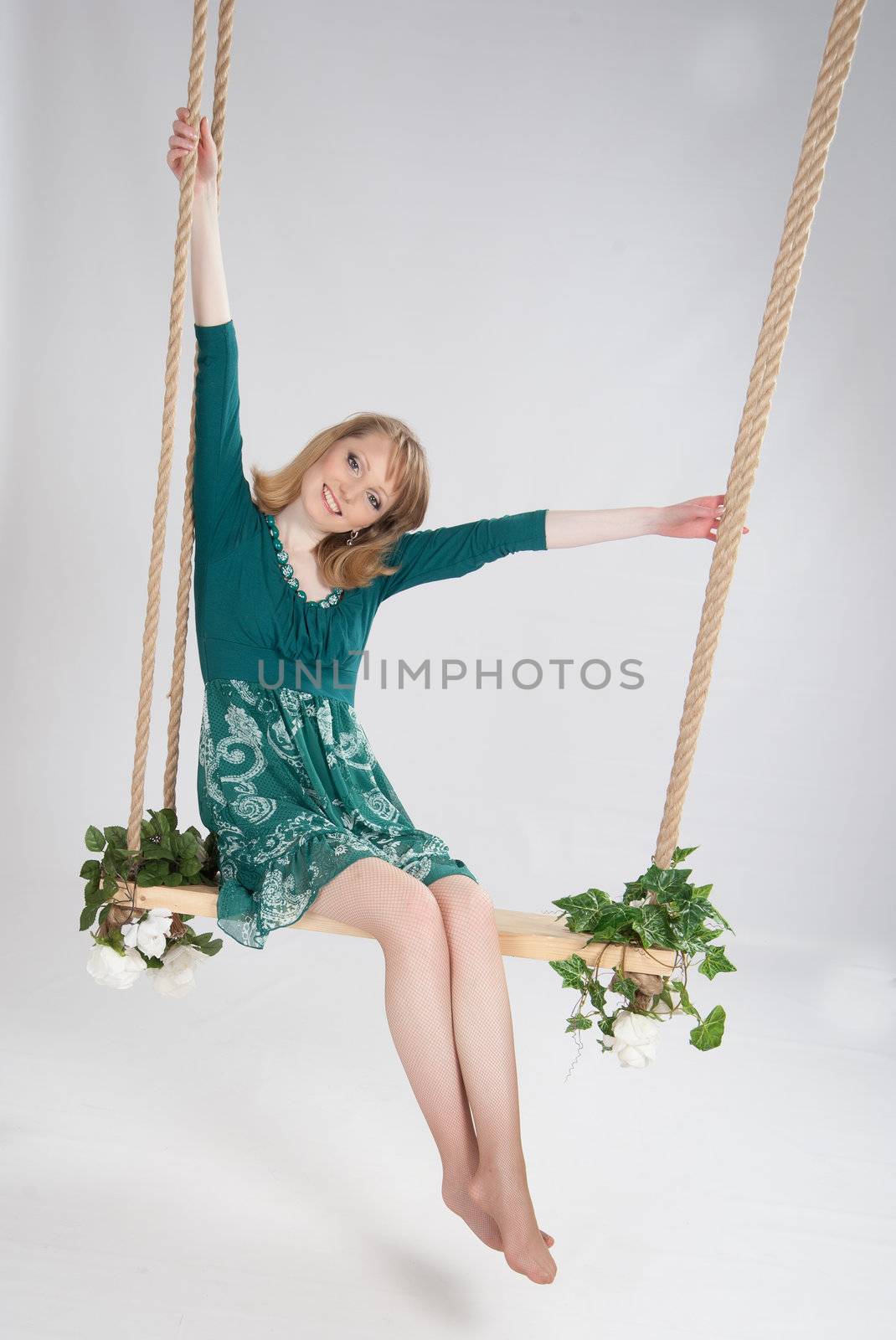 beautiful woman in a green dress on a swing