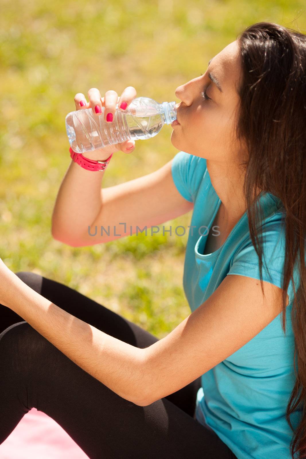 young beautiful sport woman drinking water after sport by Lcrespi