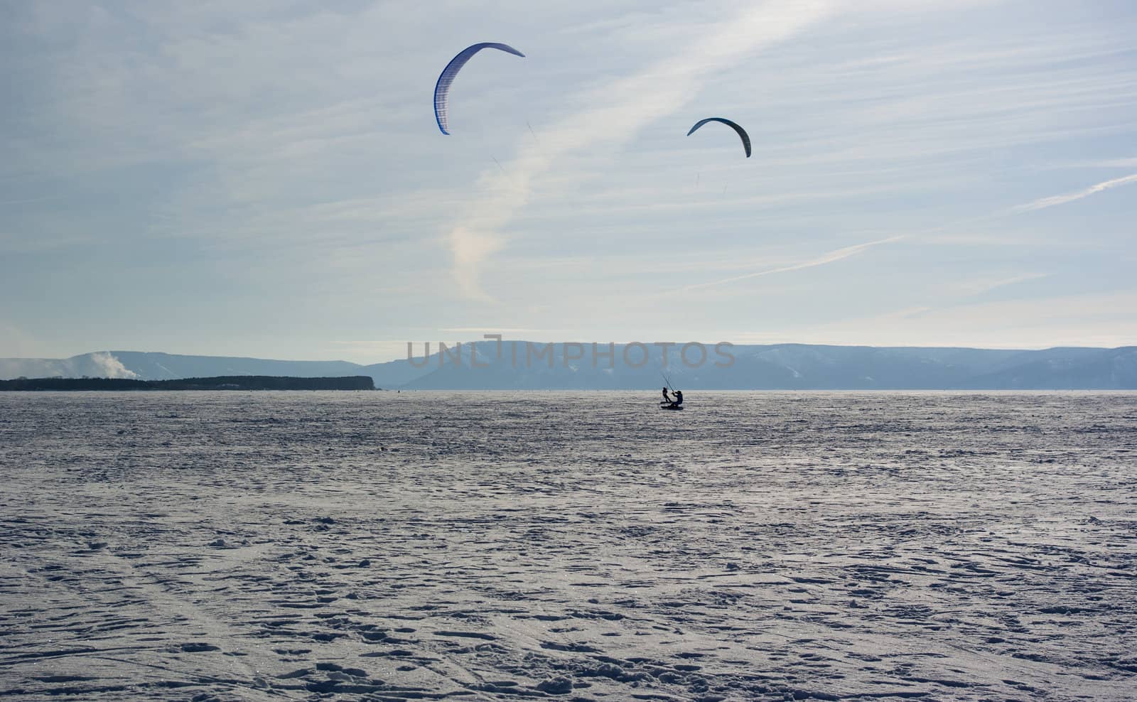 Winter kite skiing on the frozen river