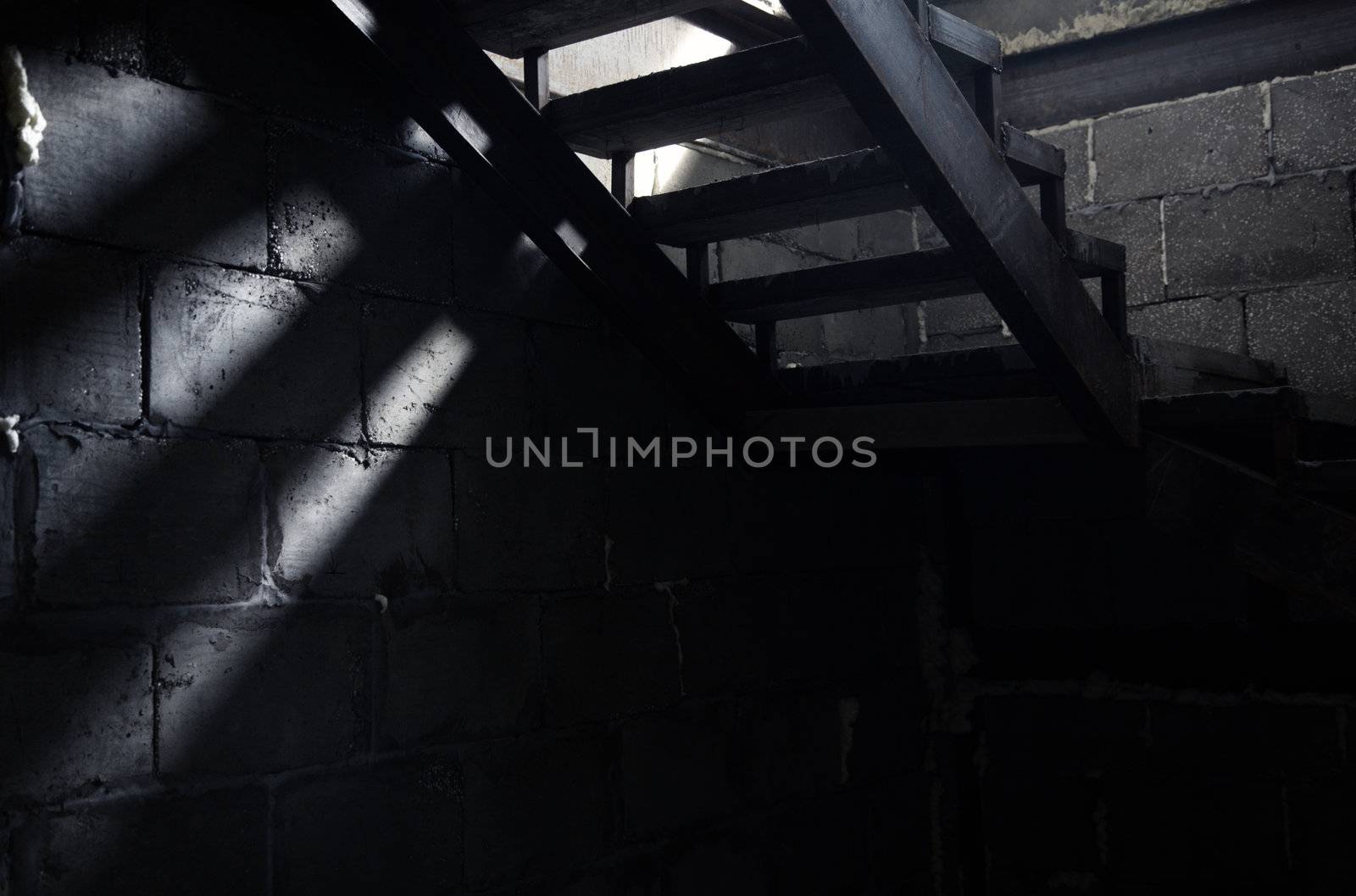 Old staircase in the dark basement. Natural light and shadows