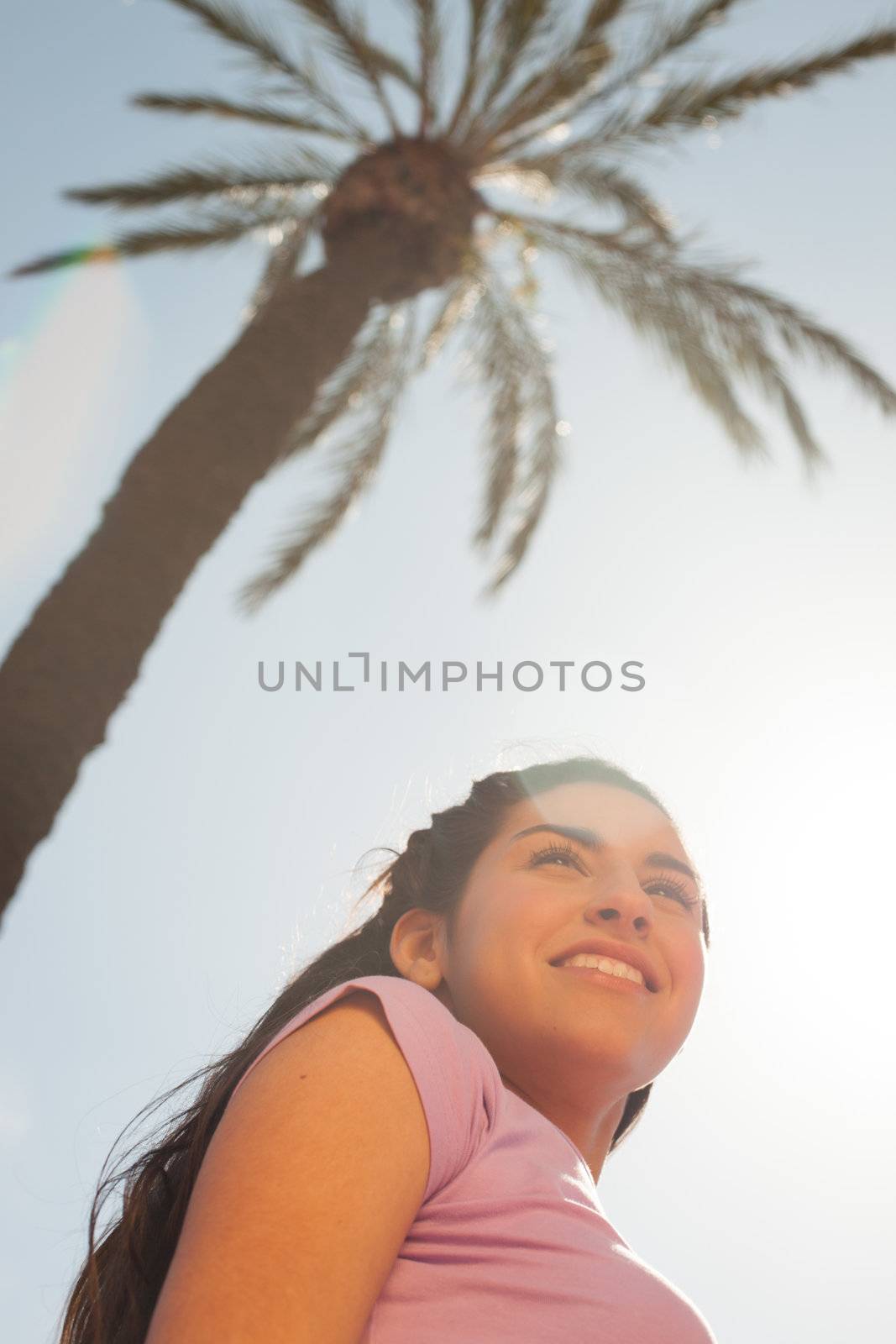 Young beautiful woman portrait with sun flare from above