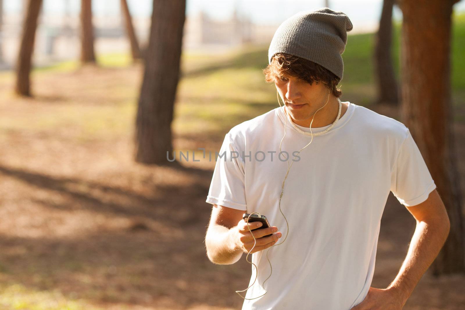 young handsome man consulting phone outdoors
