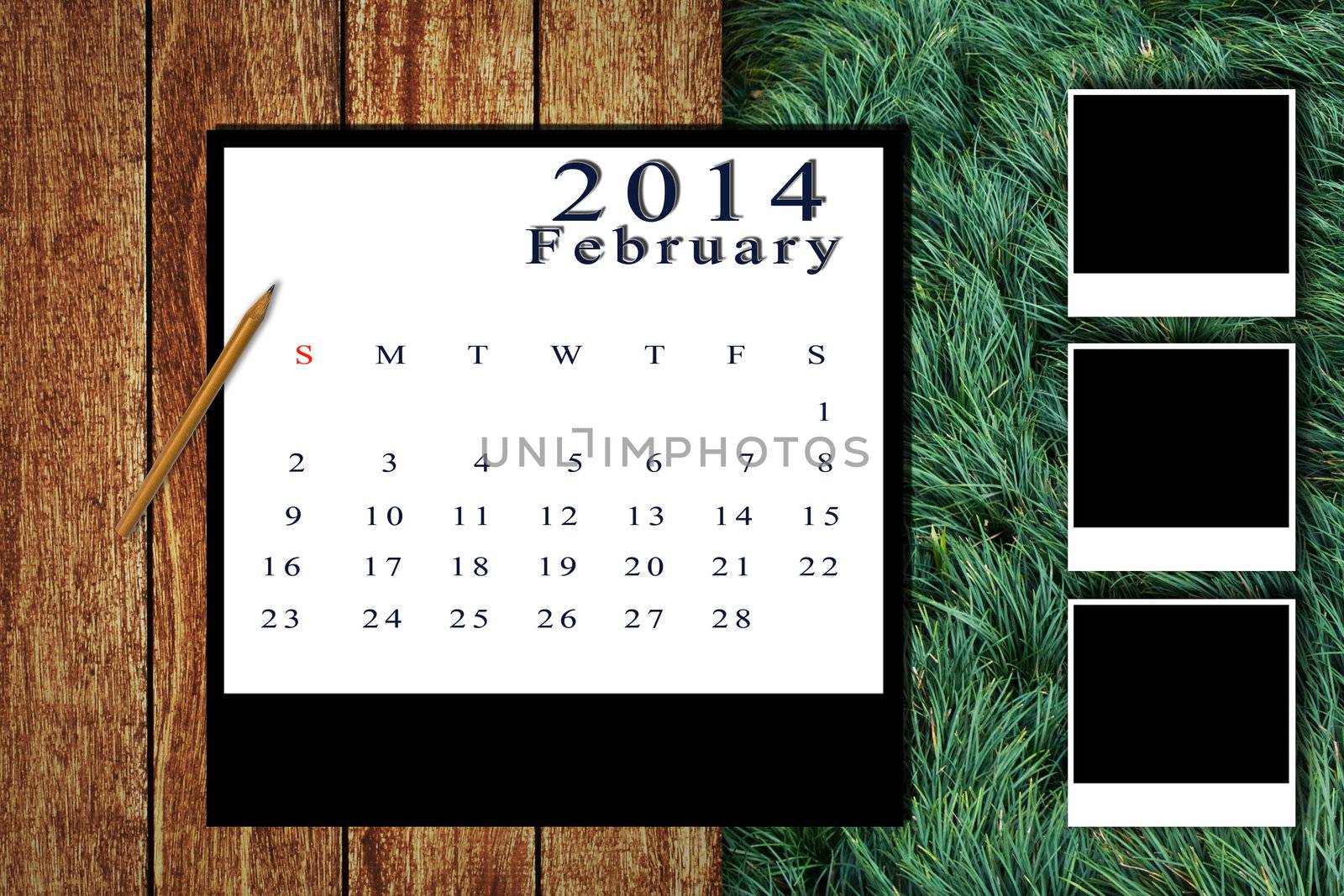 Calendar 2014 set with photo frame on wooden floor and grass background