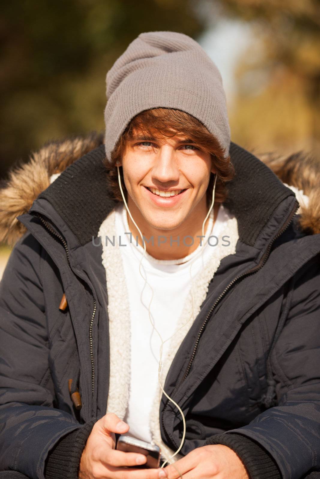 young handsome man consulting phone outdoors by Lcrespi