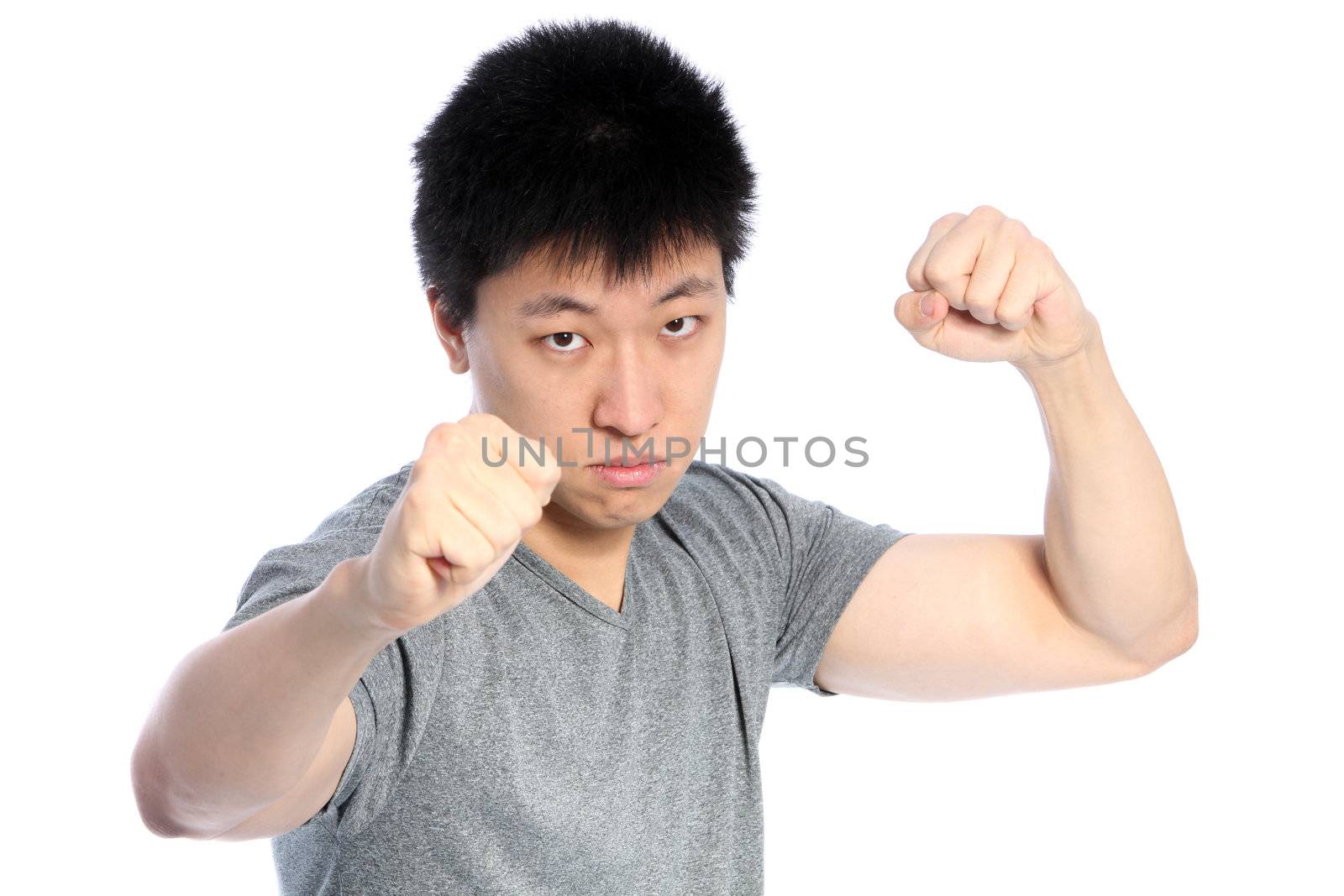 Young Asian man in fighting position, on white