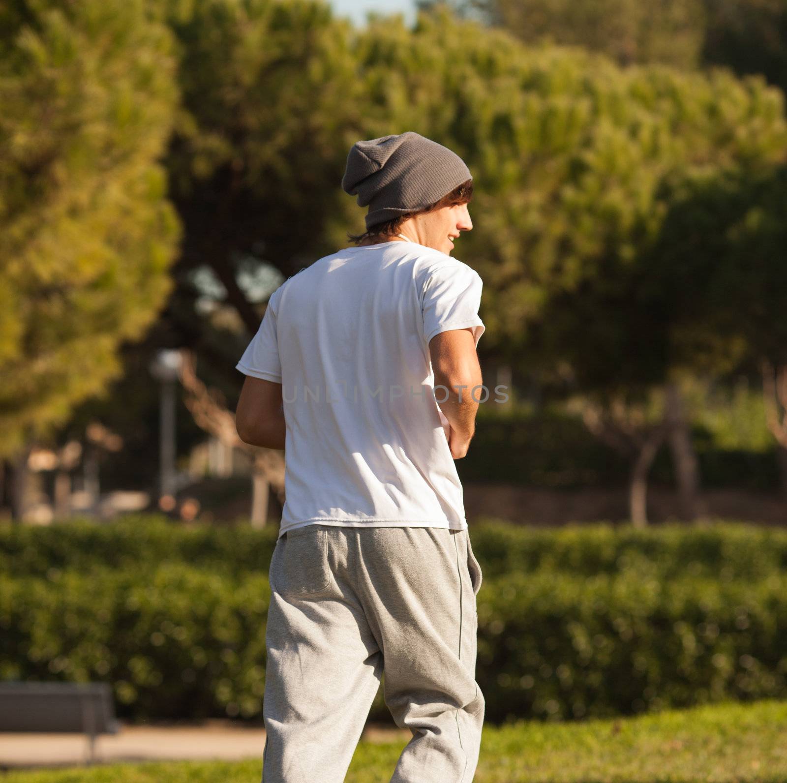 young handsome man jogging in public park by Lcrespi