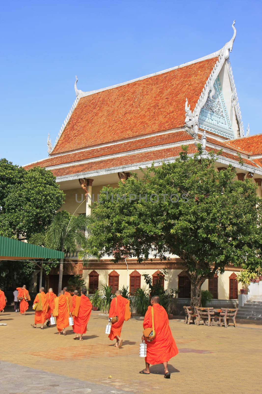 Buddhist monks walking in the courtyard of Wat Ounalom, Phnom Penh, Cambodia
